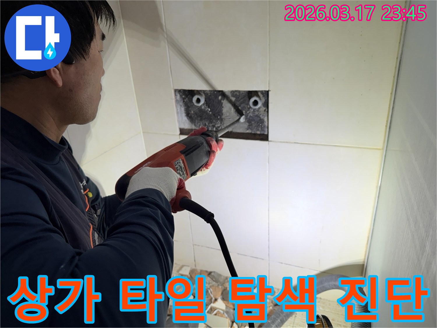 숙련된 기술자가 상가 누수 지점을 찾아내기 위해-벽면 타일을 깨고 내부 배관의 누수 부위를 정밀 탐색하고 진단하는 작업을 진행하고 있습니다.