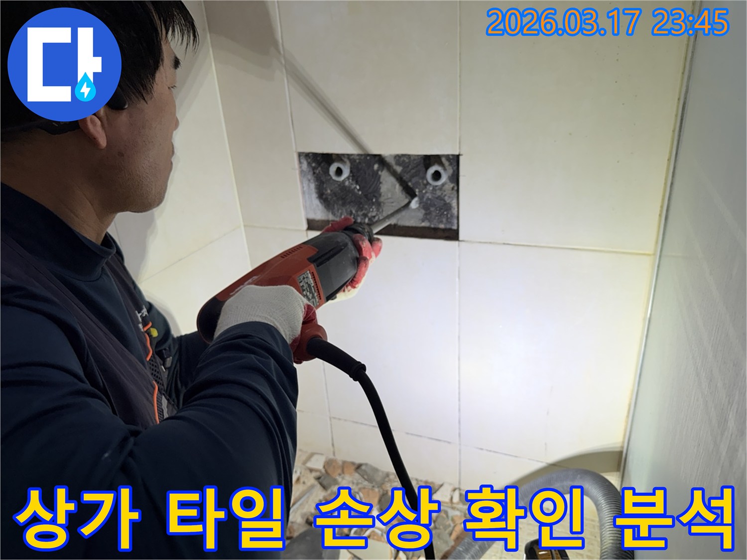 숙련된 기술자가 상가 누수 지점을 찾아내기 위해-벽면 타일을 깨고 내부 배관의 손상 부위를 육안으로 확인하고 분석하는 작업을 진행하고 있습니다.