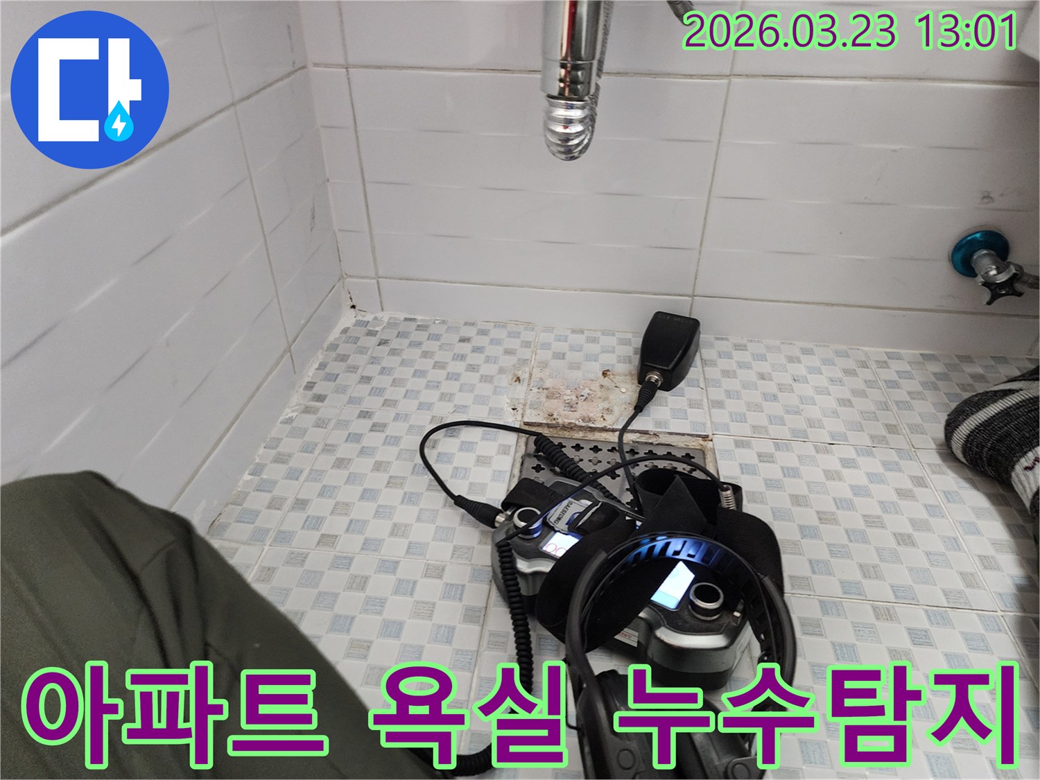 아파트 욕실 바닥에 놓인-누수탐지 장비와-헤드셋-그리고-수도관-연결된 모습