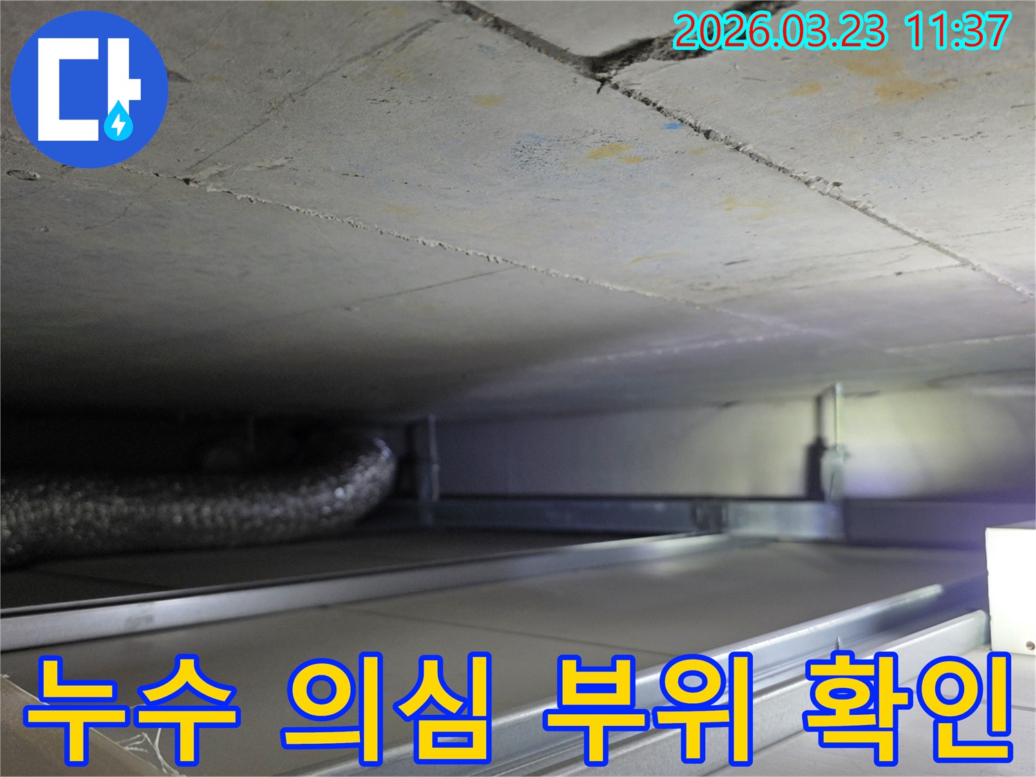 누수 공사 중-천장 내부의-복잡한-배관과-구조물을-면밀히-검토하는-과정을-보여주는-사진입니다