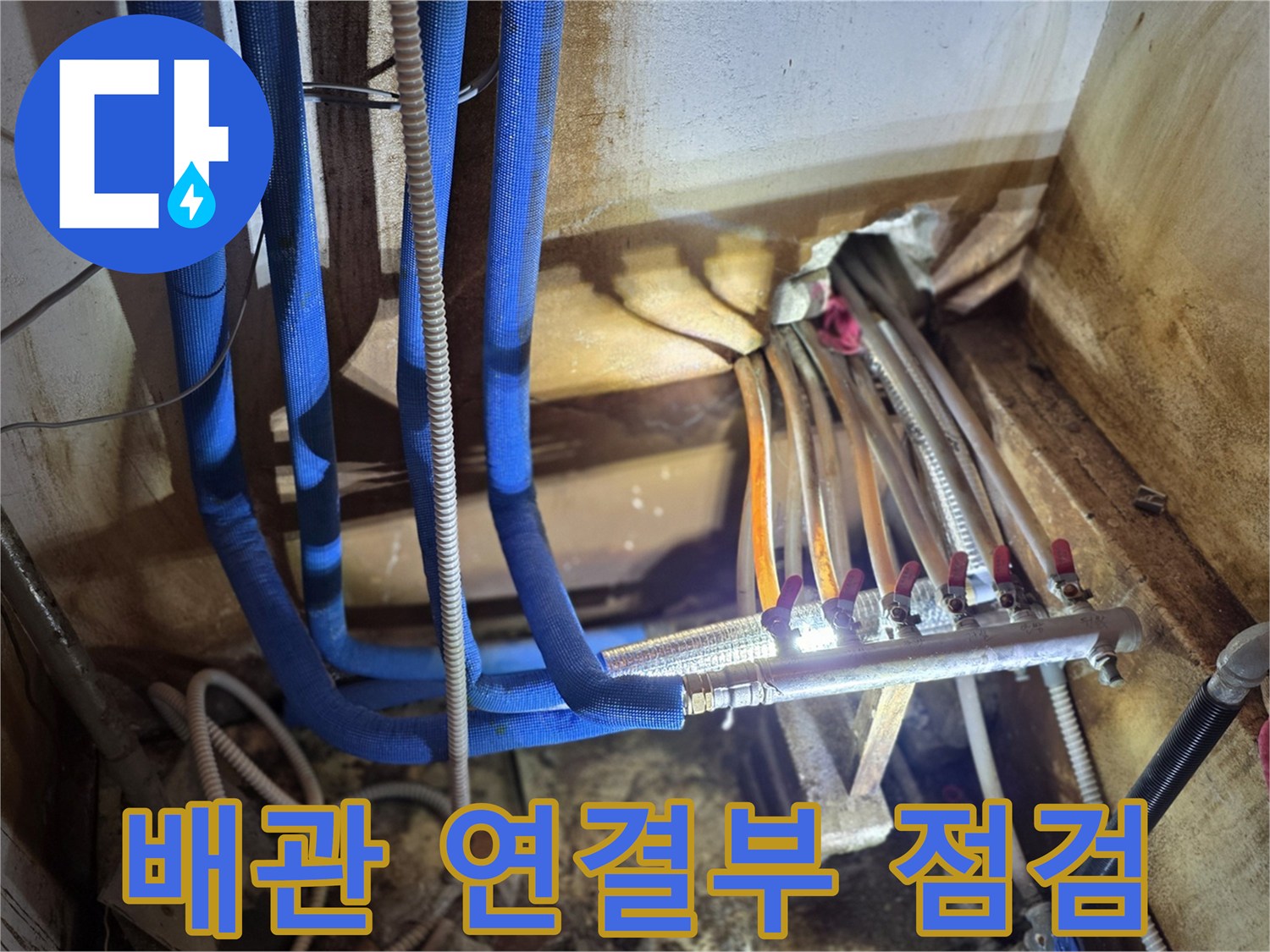 파란색 배관과-금속 분배기 부속의 누수 확인 사진