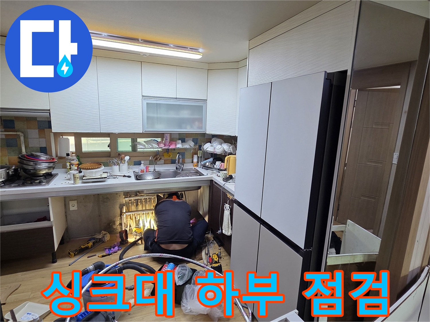싱크대 아래쪽 배관 주변의 누수 흔적을 찾는 정밀 작업