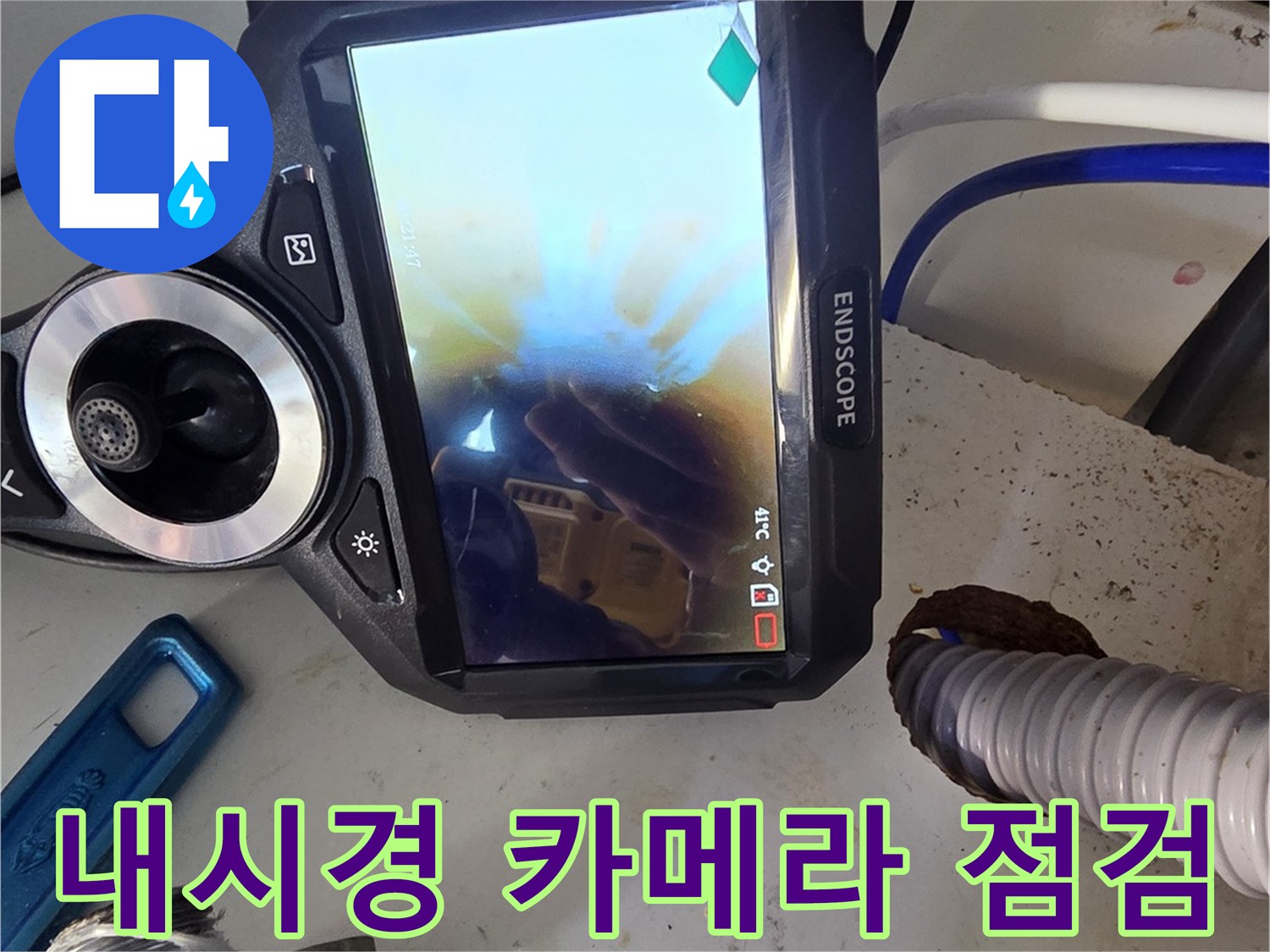 싱크대 하부 배관 내부를 촬영 중인 엔지니어의 장비