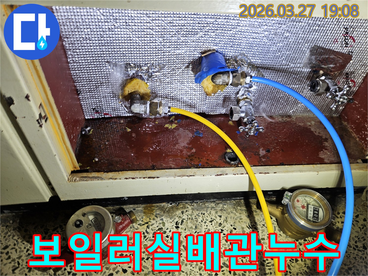 보일러실로 보이는 공간에서-배관 연결부 누수가 발생한-현장을 촬영한 사진입니다-바닥에 물이 고여있습니다