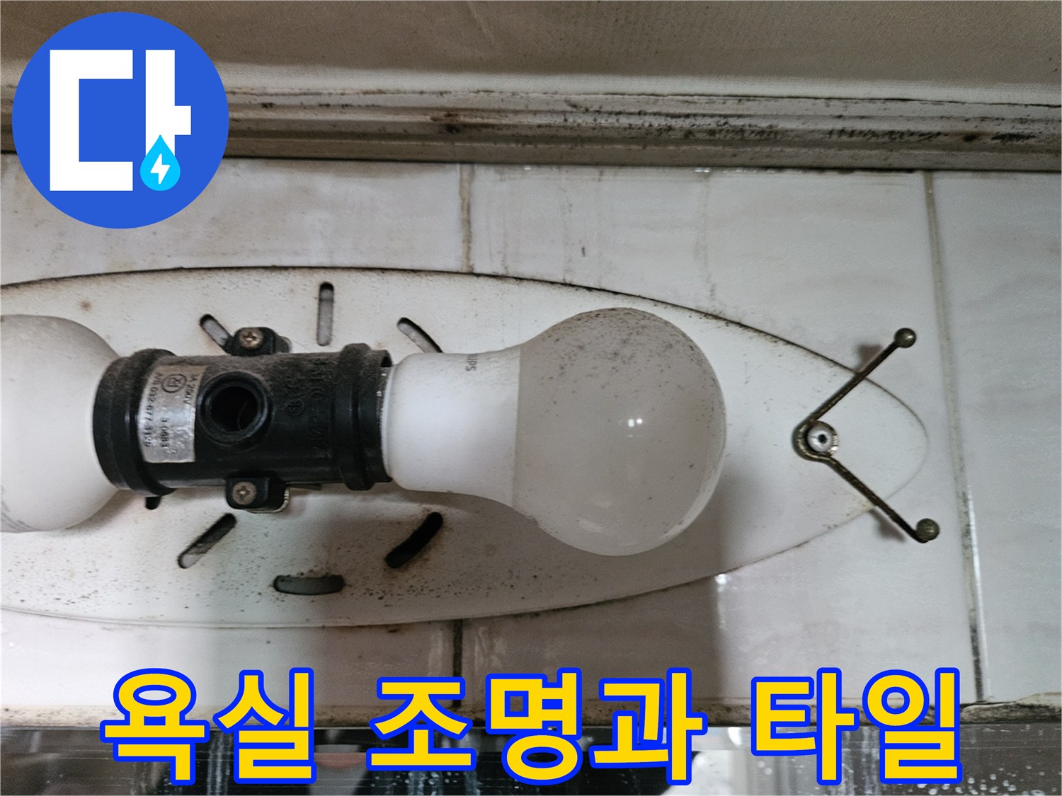 세면대 위쪽 벽면 조명 기구와 타일 마감 부위