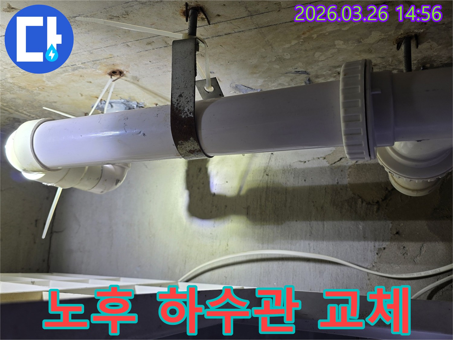 콘크리트 천장에 고정된-오래된 하수관과-녹슨 지지대의 모습으로-노후 배관 교체의 필요성을 보여줍니다