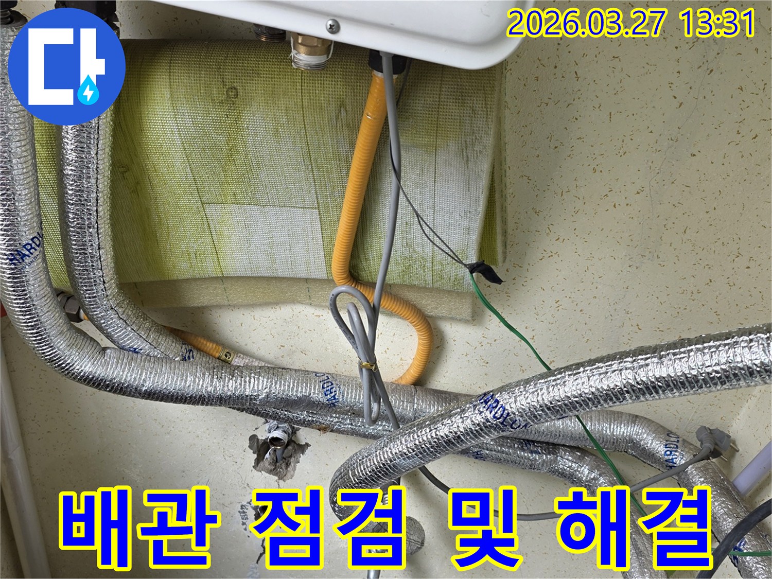 다양한-배관과-전선이-얽혀있는-보일러-하단부의-모습을-담고-있으며-누수-해결을-위한-현장-조사-중입니다.
