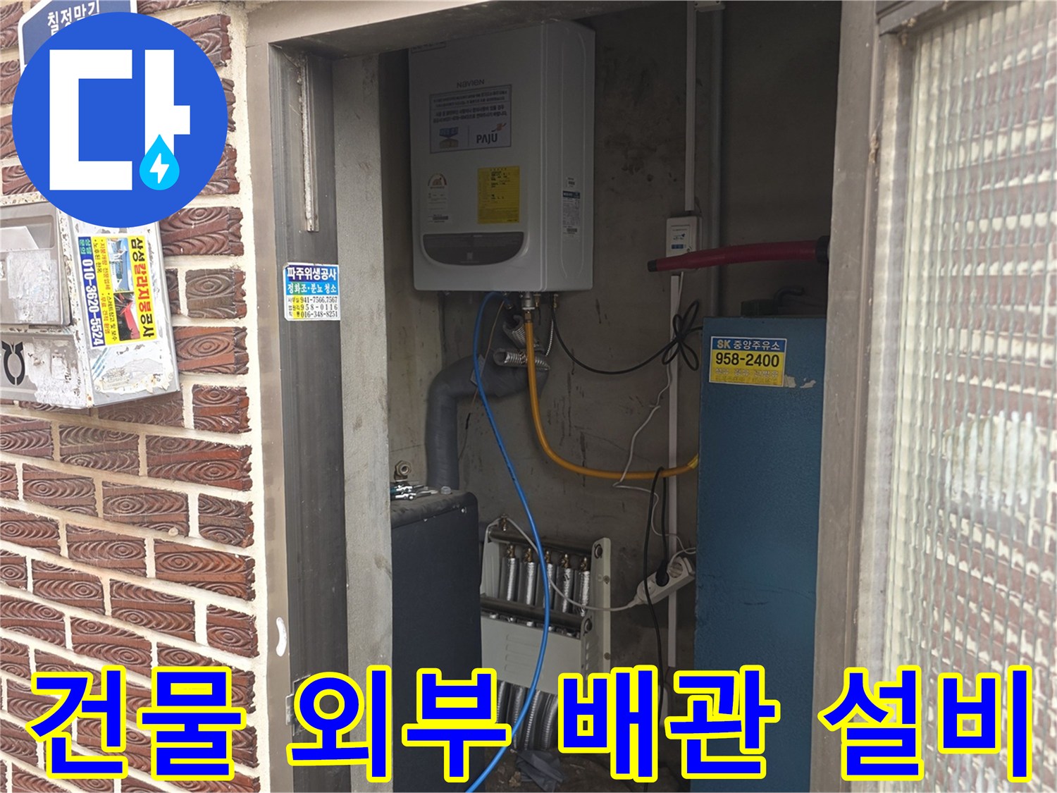 벽돌 외벽에 노출된 수도 밸브 및 전기 분전함의 모습