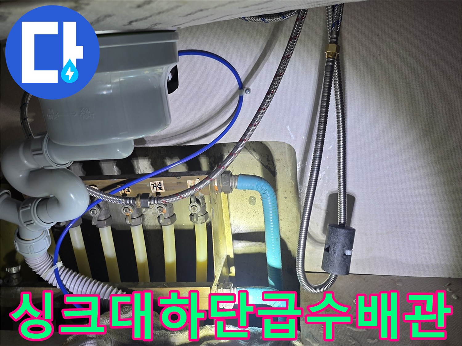싱크대 아래쪽 수도 분기 밸브와 연결된 호스들의 모습
