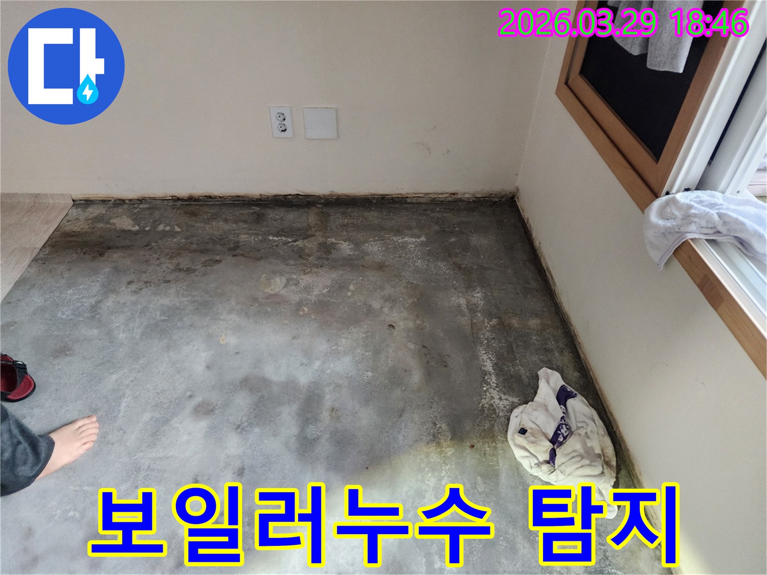이 이미지는-남양주 오남읍의 한 건물에서-바닥과 벽면 경계에-습기와 곰팡이가 발생한-누수 현장을-보여주며-보일러 누수 가능성을-시사합니다