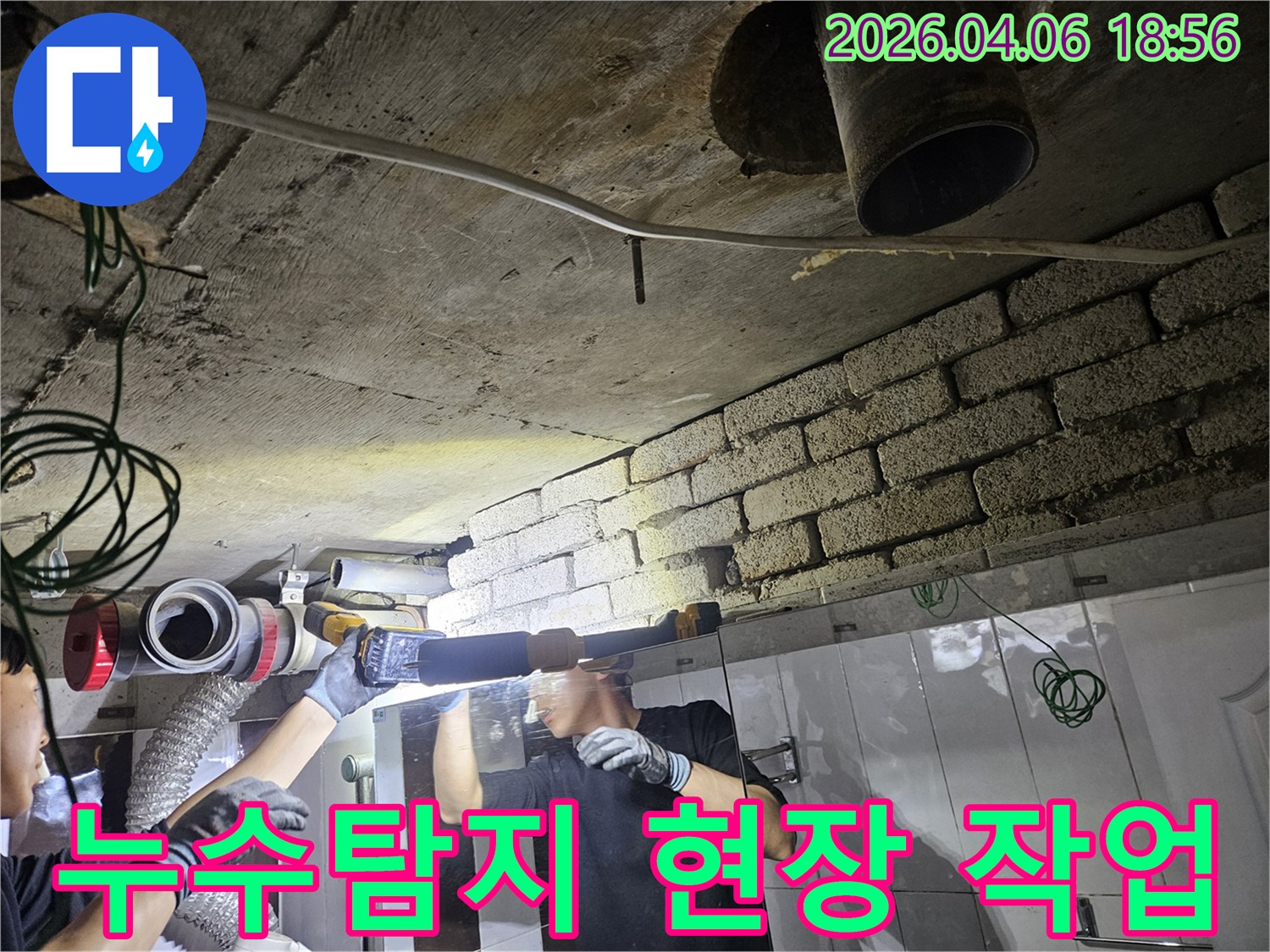 누수-탐지-전문가가-어두운-천장-아래에서-배관을-살피며-누수-지점을-찾는-모습