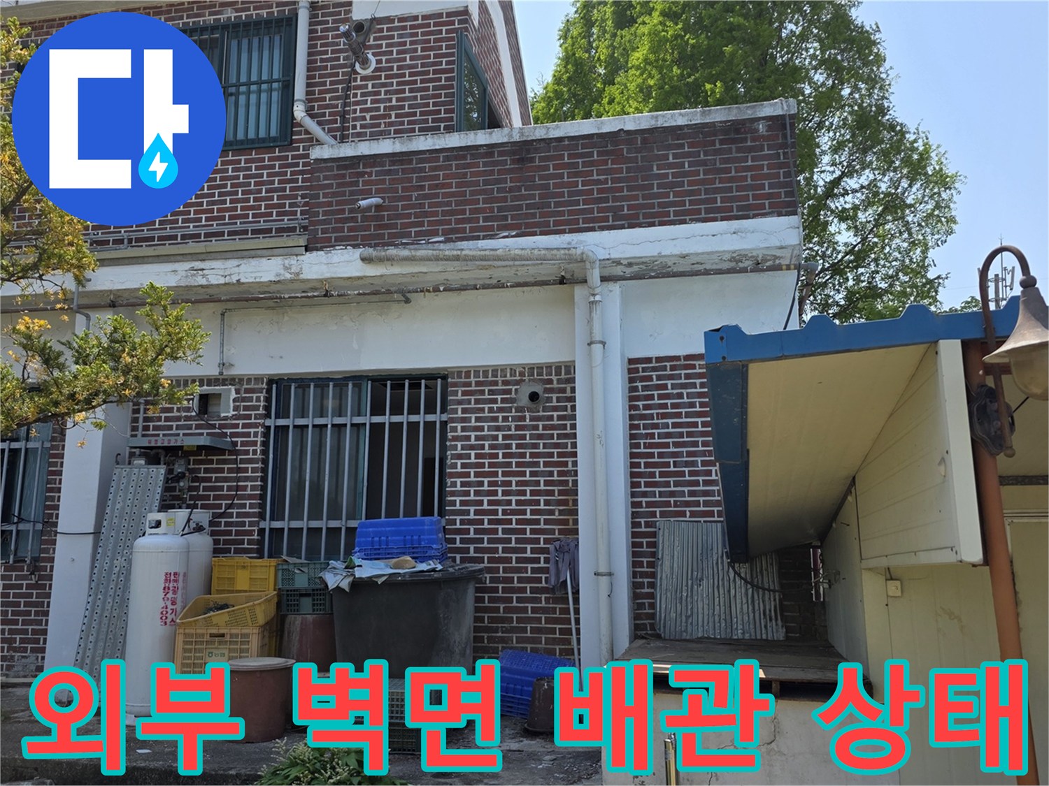 양주 백석읍-벽돌 건물 외벽에 노출된 배관 및 주변 시설물입니다.