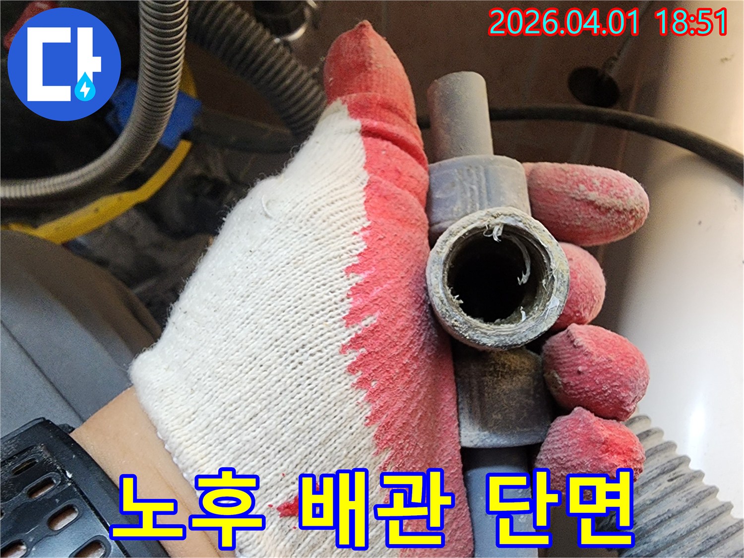 작업용 장갑을 낀 손으로-오래된 배관의 내부 부식 상태를-자세히 보여주는 장면
