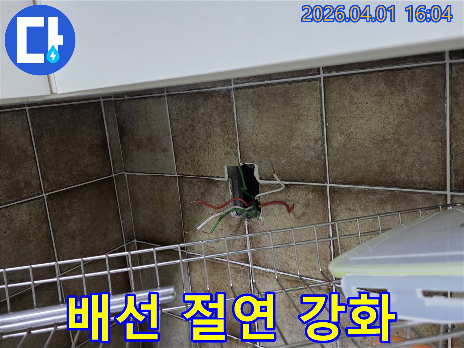 누수 수리 현장에서 벽면 타일이 제거된 후-다양한 색상의 전기 배선이 드러난 모습을 보여주는 사진입니다-이는 전기 안전 점검의 필수 과정을 나타냅니다.