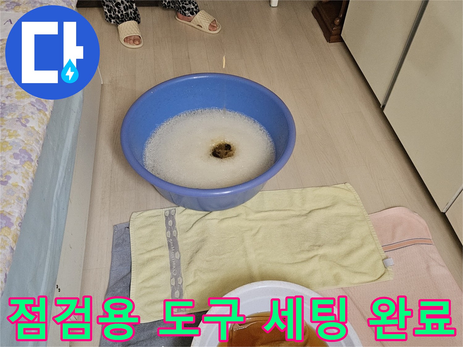 배관 주변의 습기를 제거하기 위해 준비된 대야와 수건
