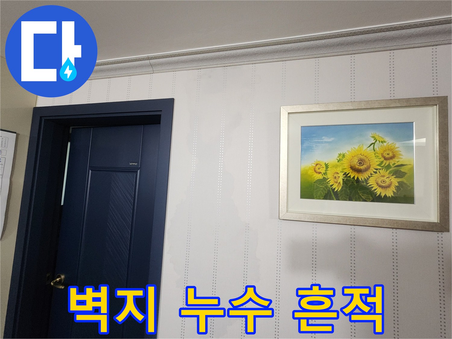 거실 문 옆 벽지의 젖은 얼룩 부위