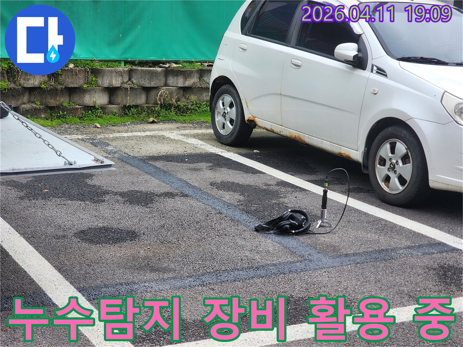 주차장 바닥에 물기가 보이는 곳에서-누수 지점을 찾기 위해-청음식 탐지 장비를 설치하여 활용 중인 모습입니다.