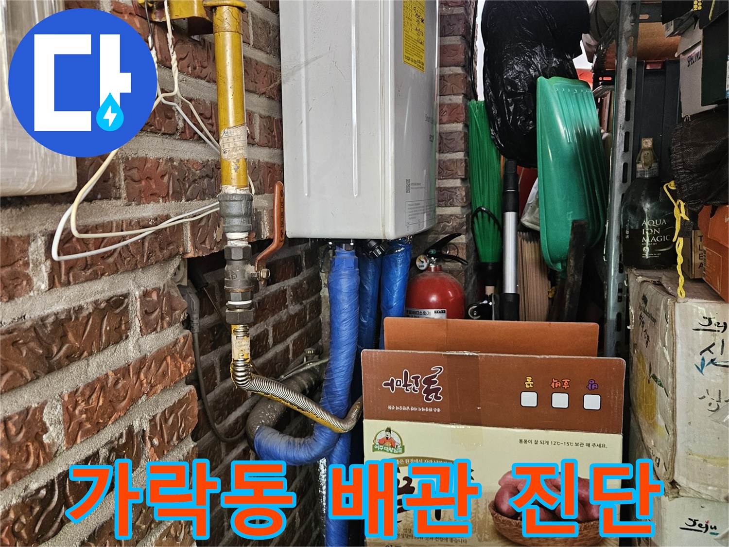 송파구 현장-다용도실 하부의 파란색 호스와 노란 가스 배관 연결 부위 근접 촬영
