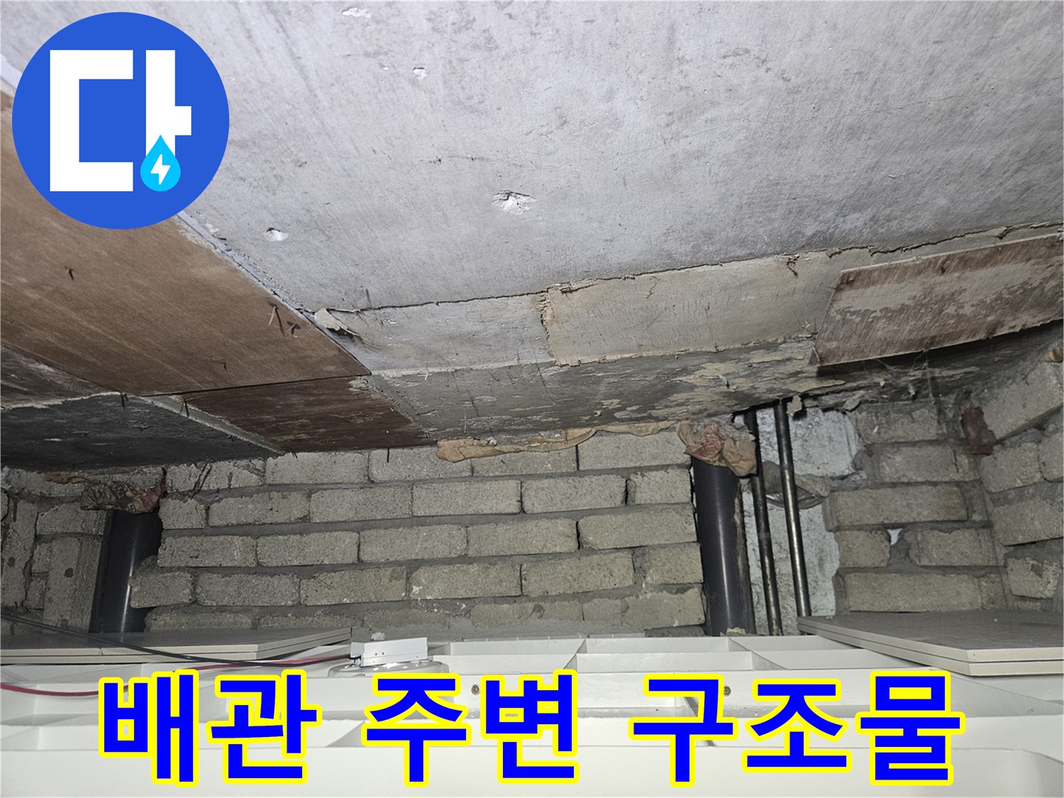 천장 내부의-배관과 벽돌 및 나무 판재 모습