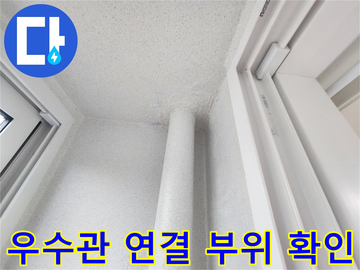 하얀색 수직 배관과 인접한 벽면의 모습입니다.