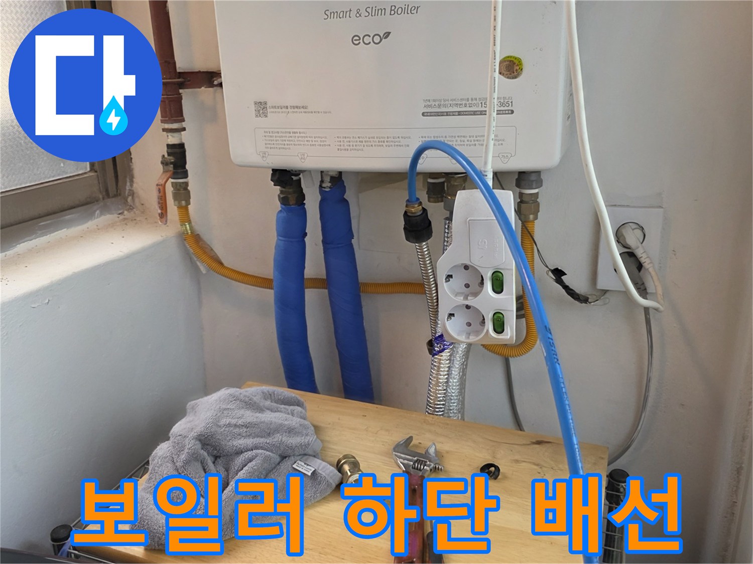 보일러-하부의-배관과-전기-콘센트-연결부