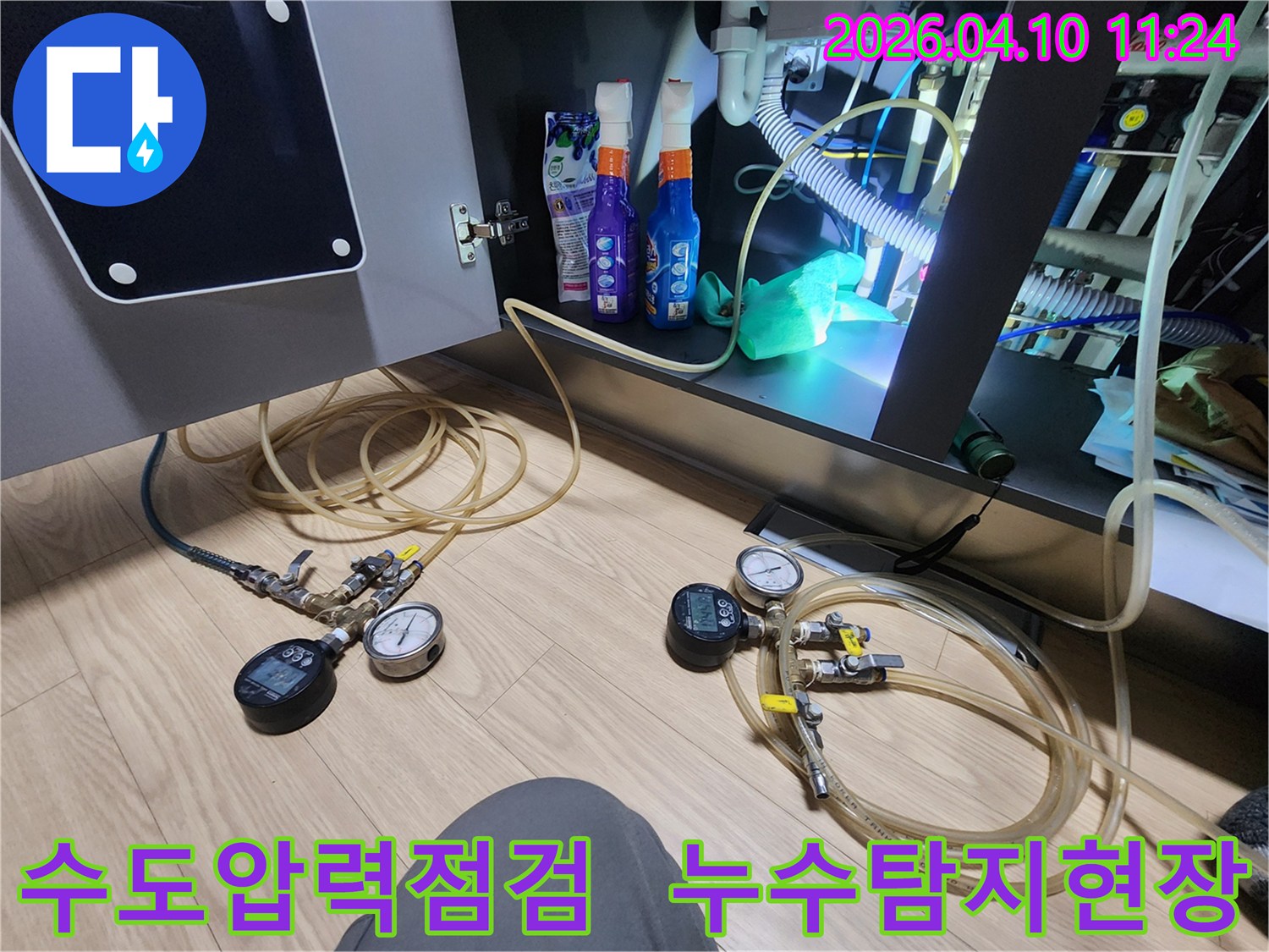 수도 배관의 건전성을 확인하고자-압력 게이지와 연결된 호스를 통해-정밀하게 검사하는-누수 탐지 작업 사진입니다.