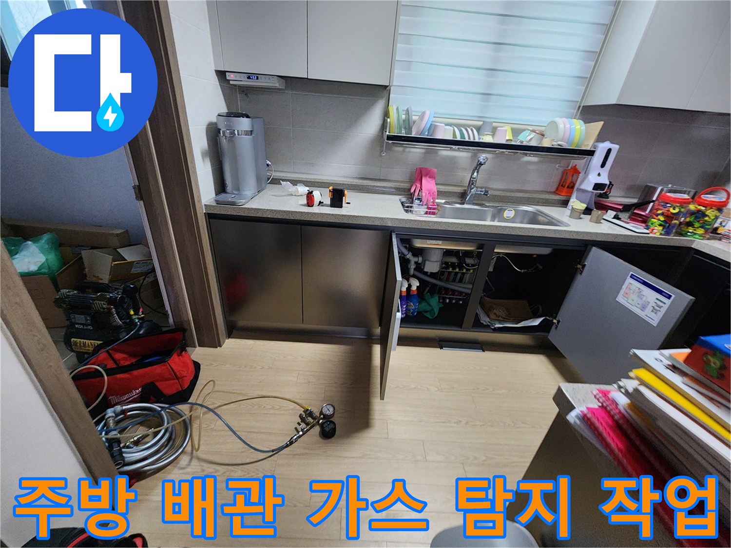싱크대 하부 공간-배관 누수를 찾기 위해 설치된 가스 탐지 호스와 장비들