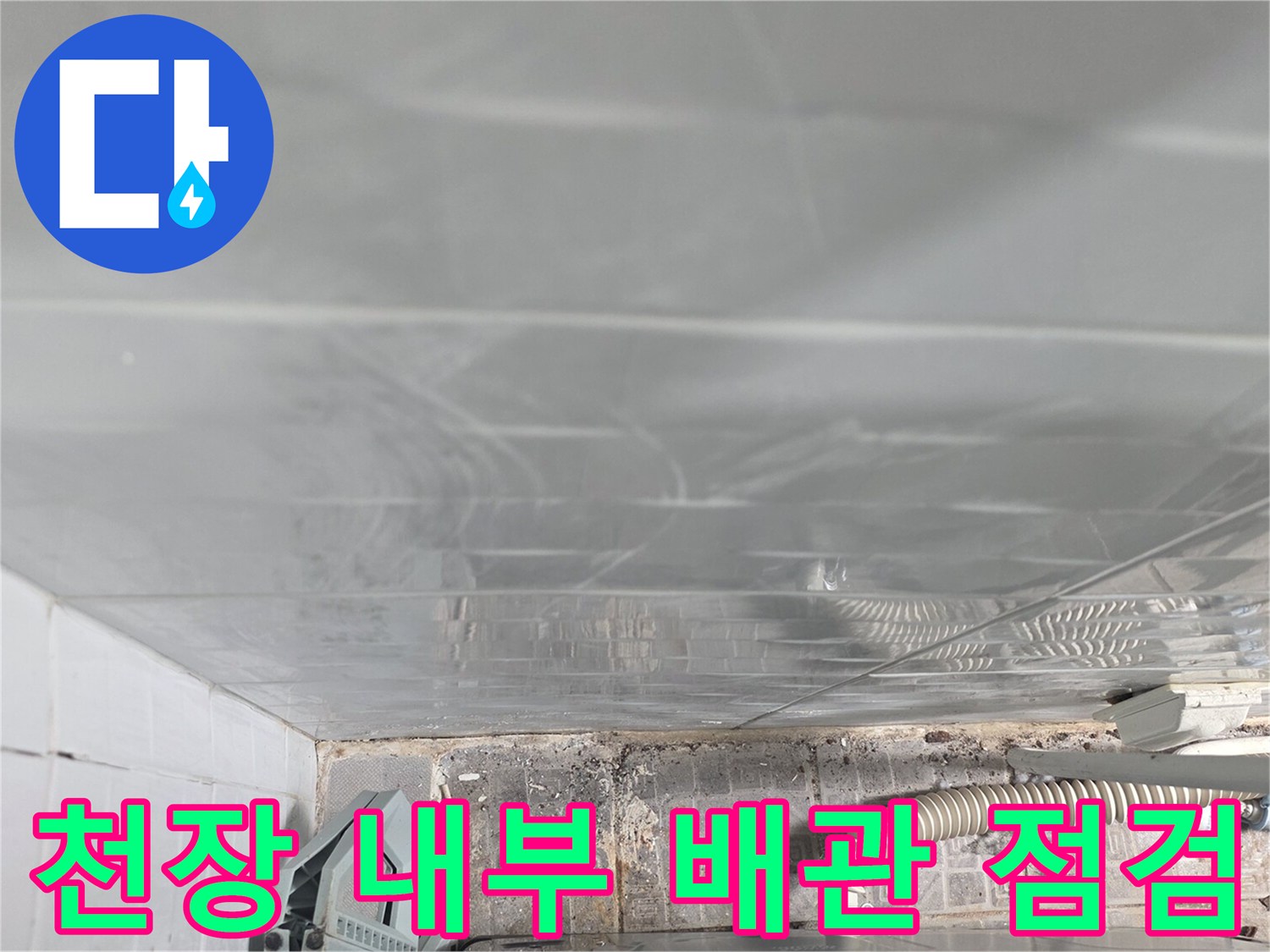천장 텍스 사이로 보이는 배관과 습기가 찬 천장 내부 모습입니다.