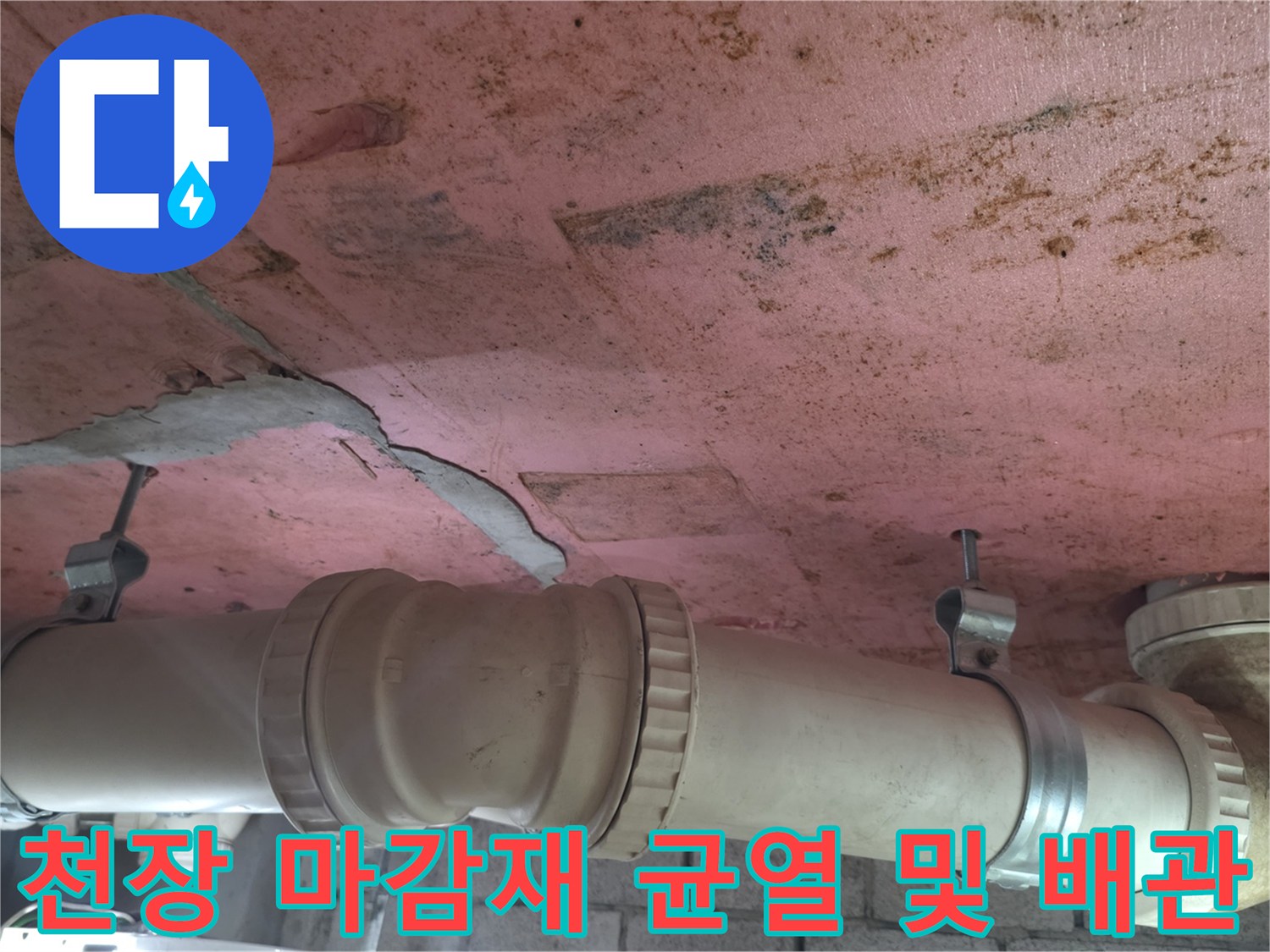 균열된 분홍색 천장과 연결된 하수 배관 모습