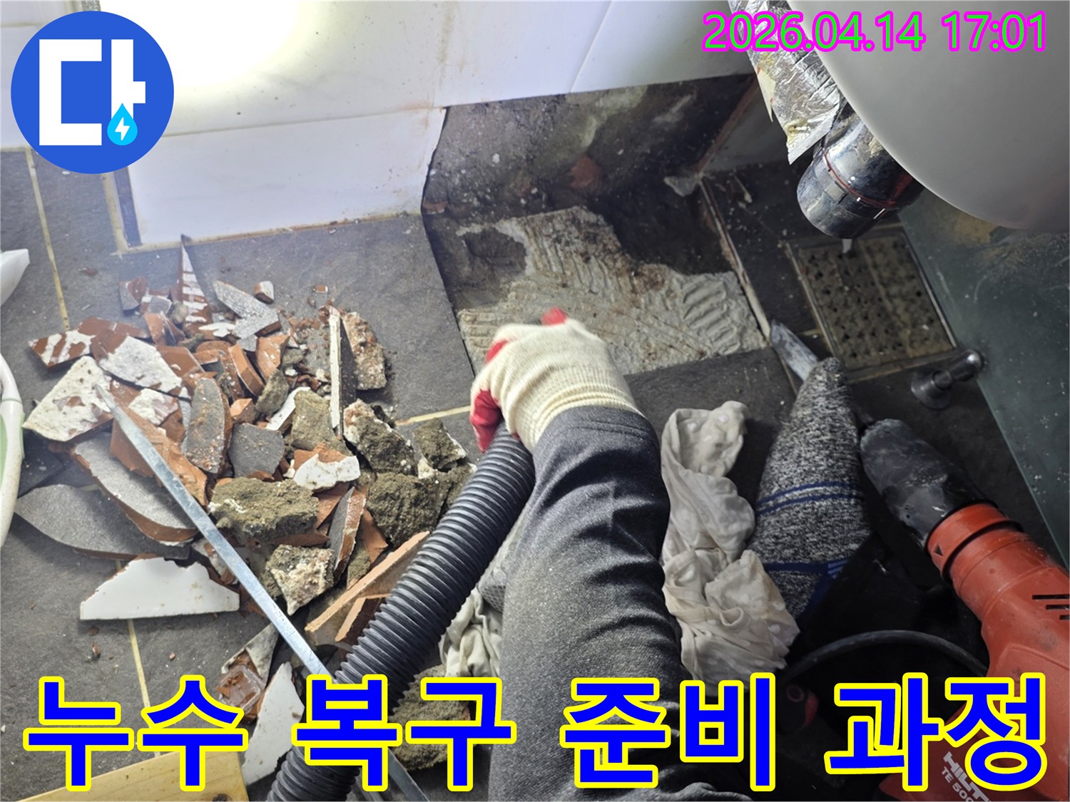 타일 철거로 인해 발생한-콘크리트 조각과 먼지를-산업용 청소기로 흡입하는 장면입니다.