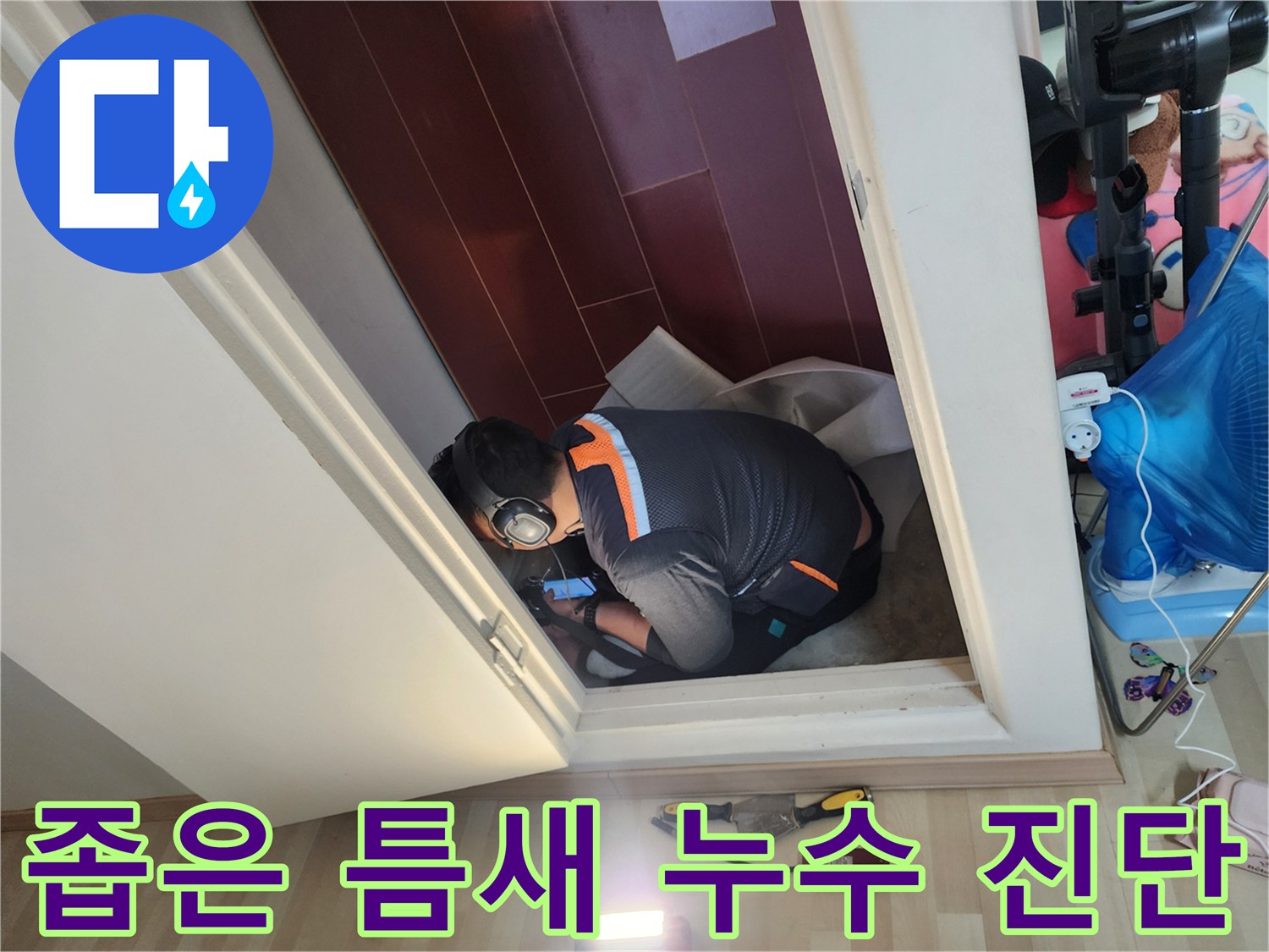 문 아래쪽 공간에서 진행되는 배관 누수 점검 현장
