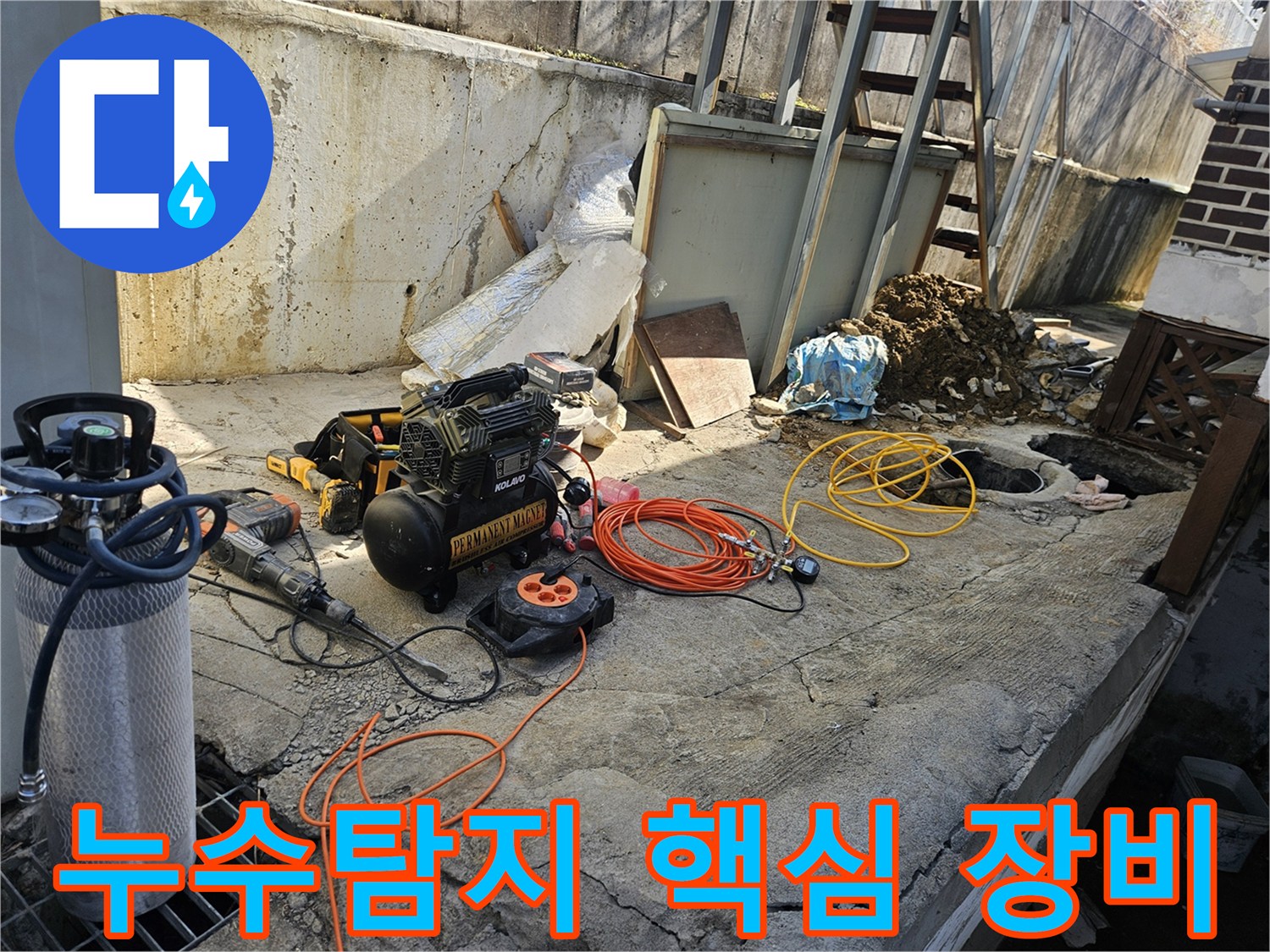 누수 공사를 위한-에어 콤프레셔-함마드릴-호스-전선릴 등-다양한 전문 장비들이-콘크리트 바닥 위에-정돈되어 있는-작업 준비 현장