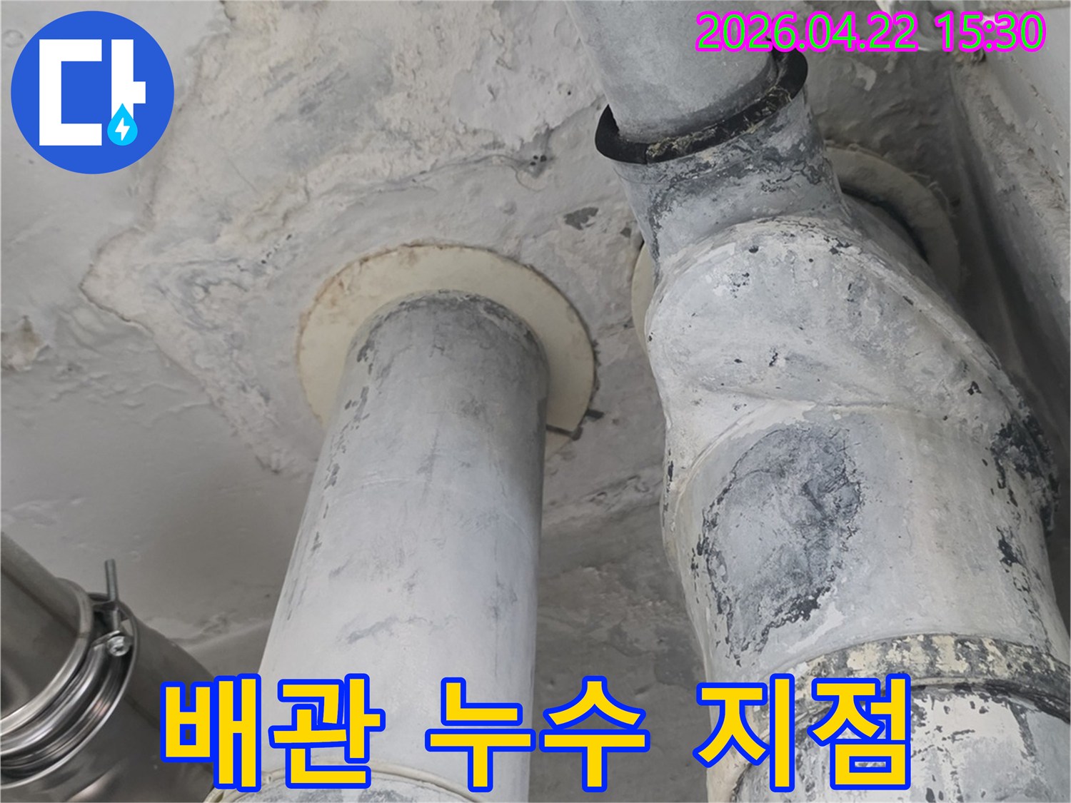 아파트 천장 배관에서-물이 새어 나와 주변 벽면이 젖은-누수 지점을 명확히 보여주는 사진입니다.