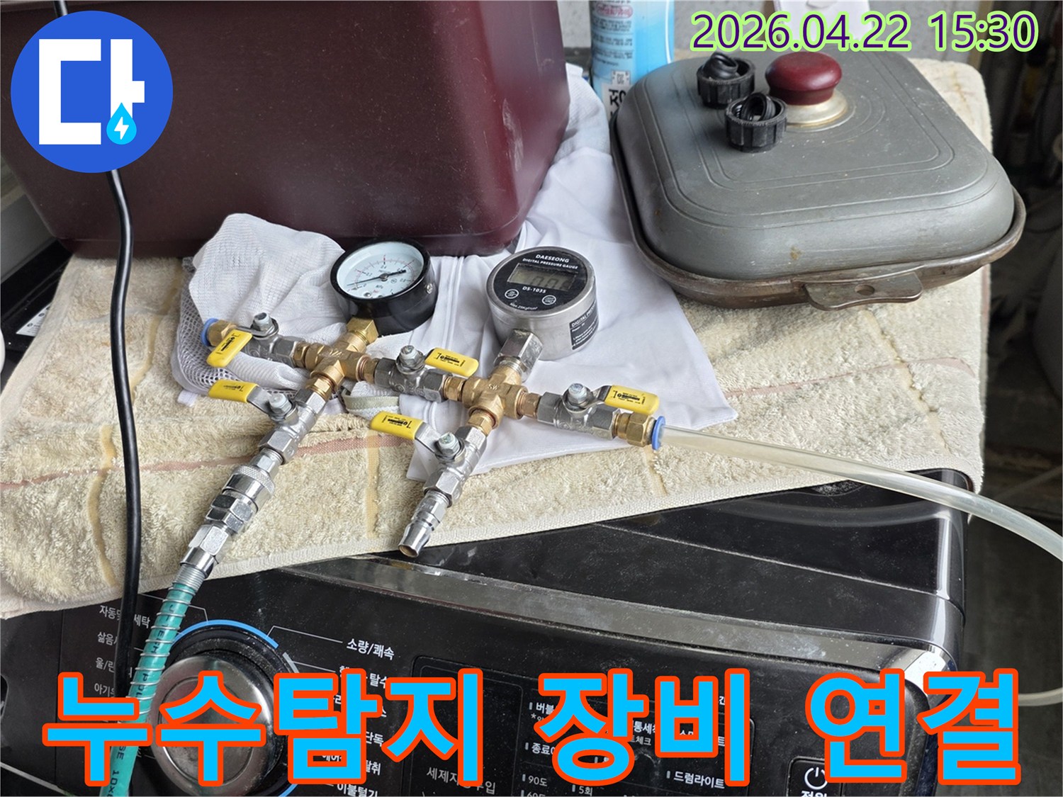 온수 배관의 누수 여부를-확인하기 위해-정밀한 압력계와-유량계가 장착된-탐지 장비를-연결하는 작업입니다.