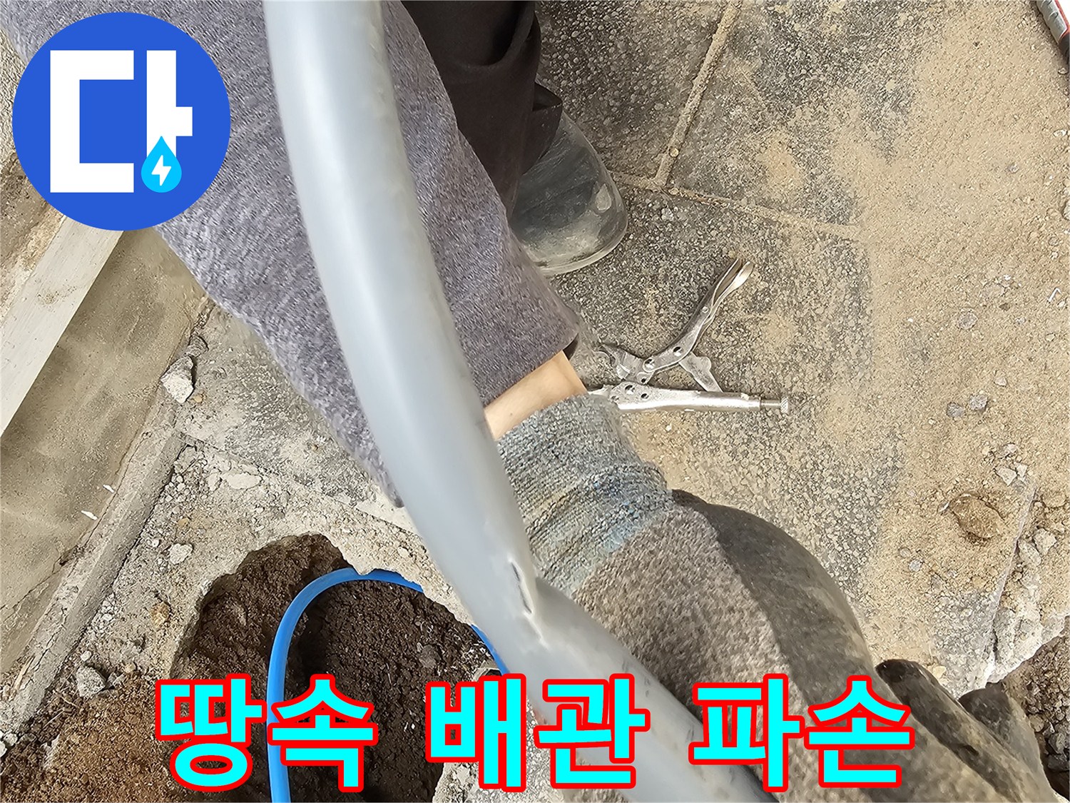 땅을 파서 드러난 파손된 배관을 엔지니어가 면밀히 검토하는 현장