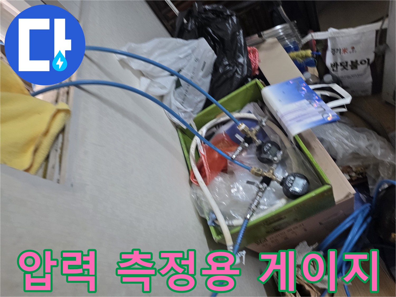 누수 지점을 찾기 위해 연결된 파란색 호스와 압력 계측기
