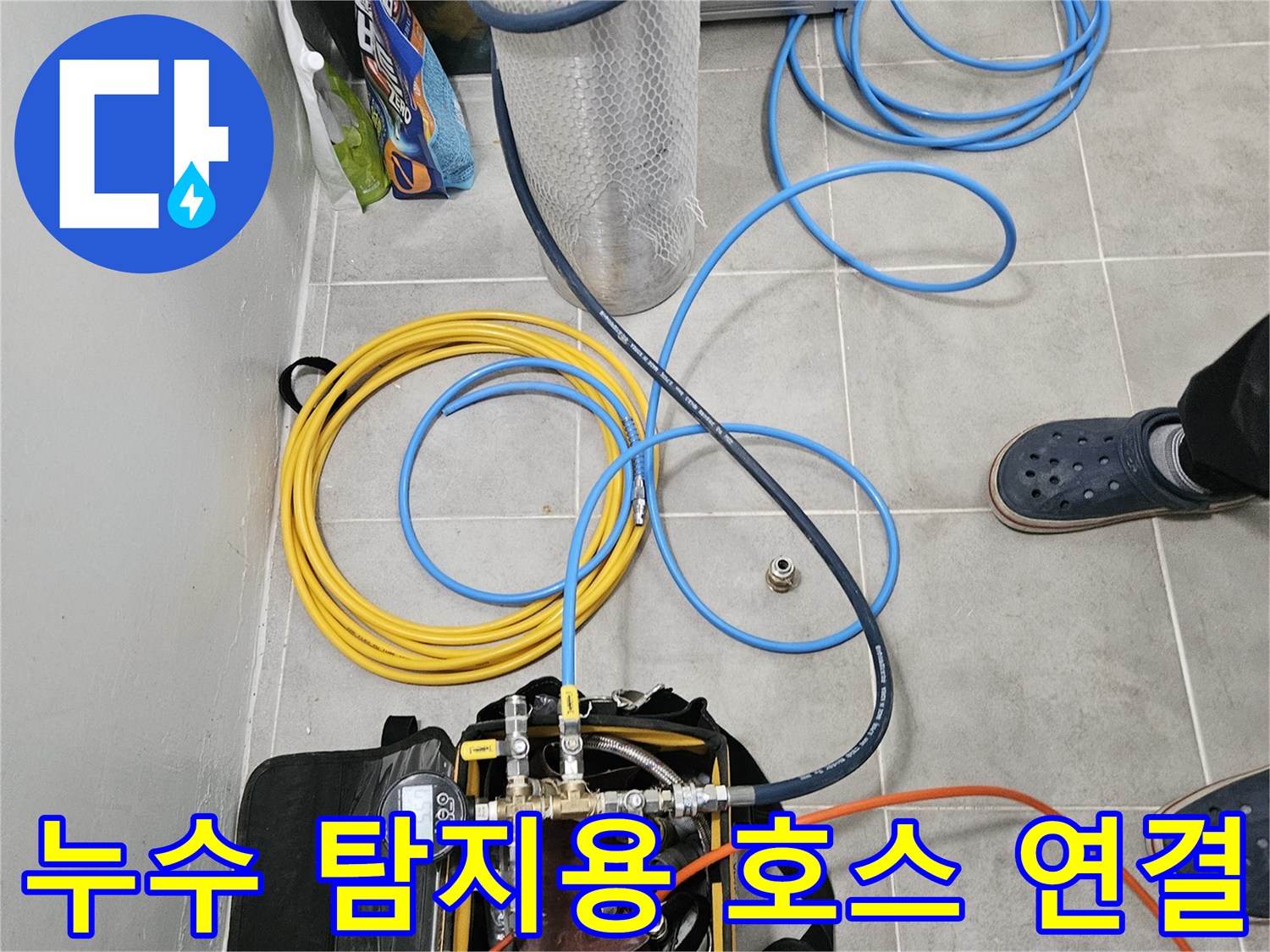 바닥에 펼쳐진 파란색과 노란색의 배관 검사용 호스 세트
