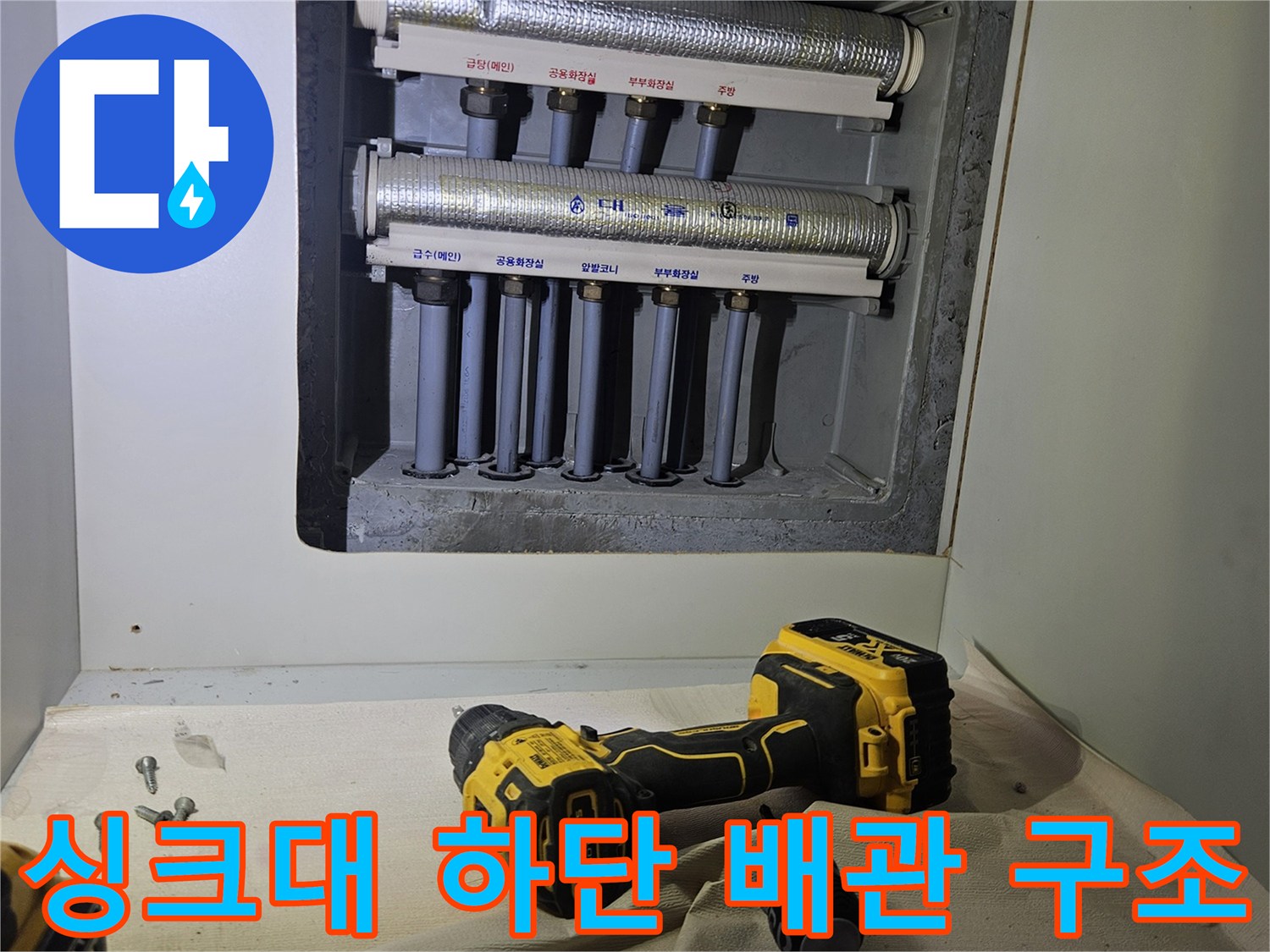 싱크대 아래 분배기와 연결된 여러 개의 급수 배관들