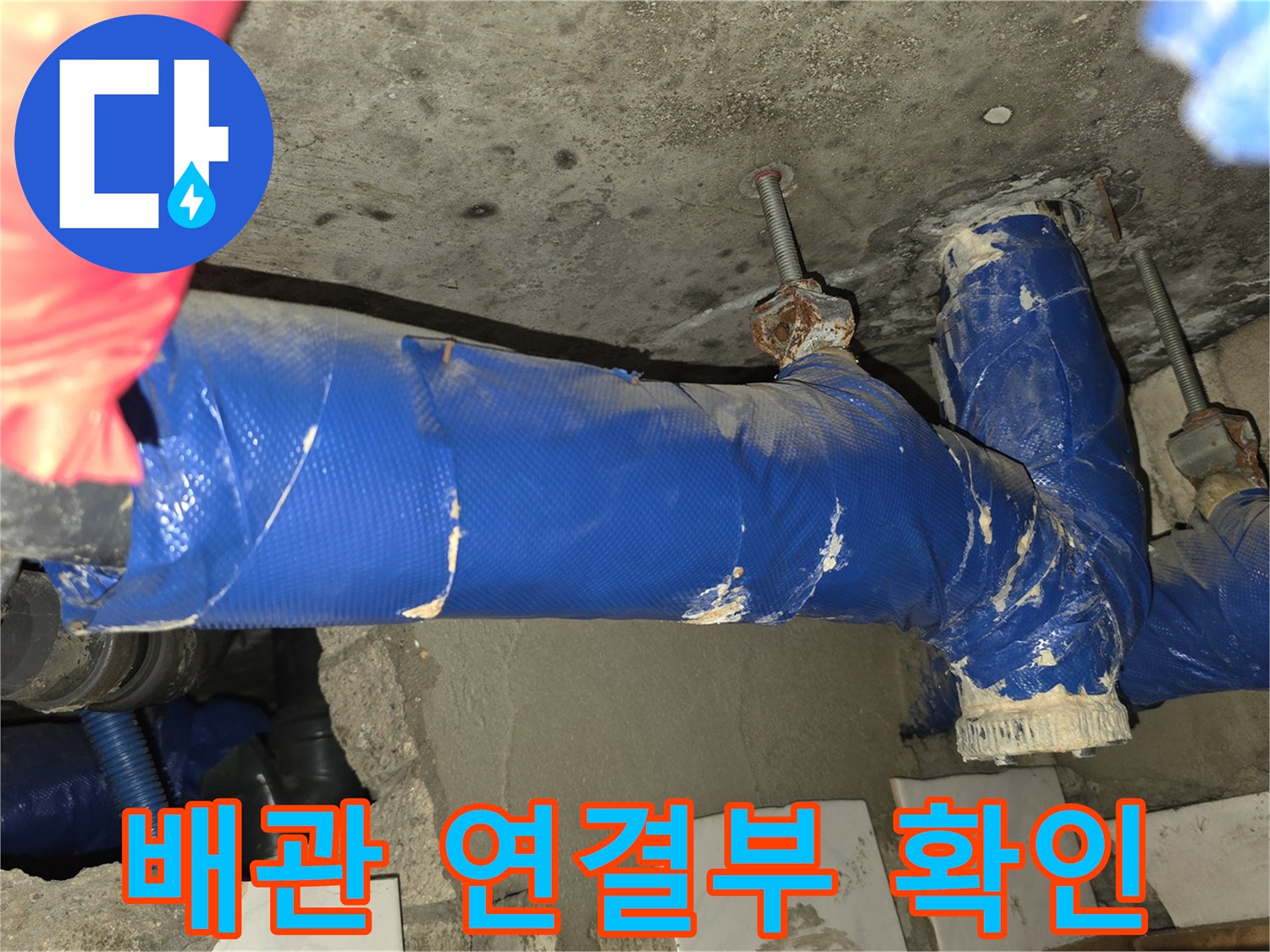 파란색 보온재로 감겨 있는 배관의 엘보우 연결 부위 근접 촬영