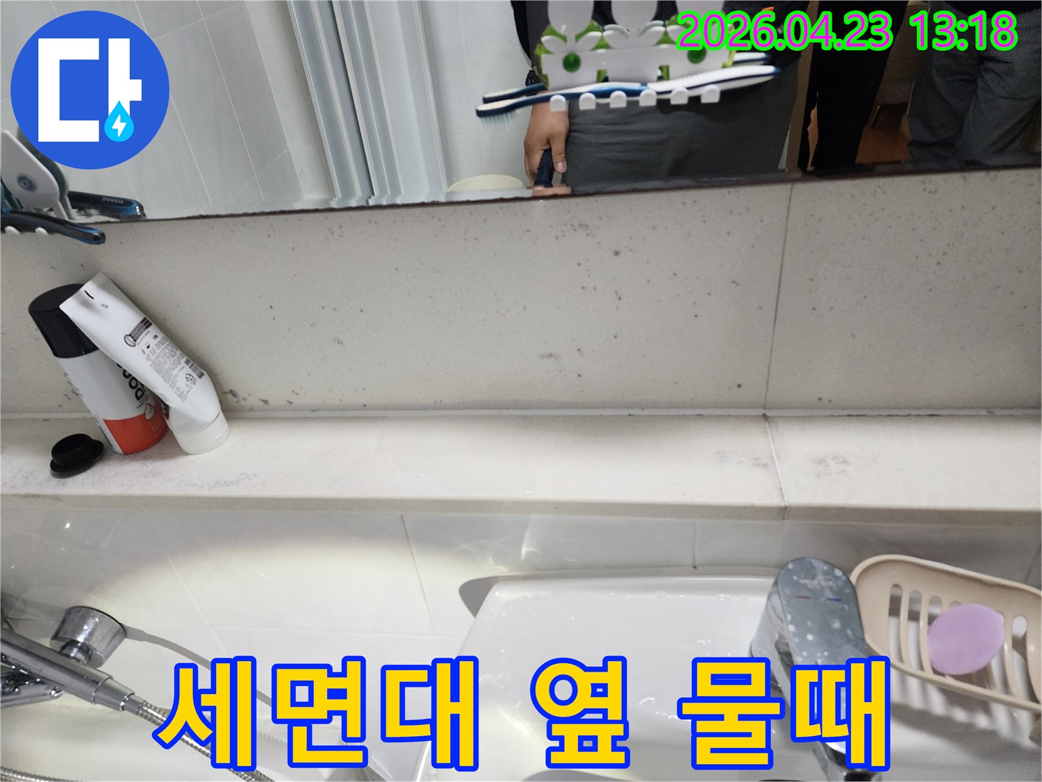 욕실 세면대 옆-벽면에 나타난-지속적인 물기로 인한 물때와 얼룩을 보여주는 사진