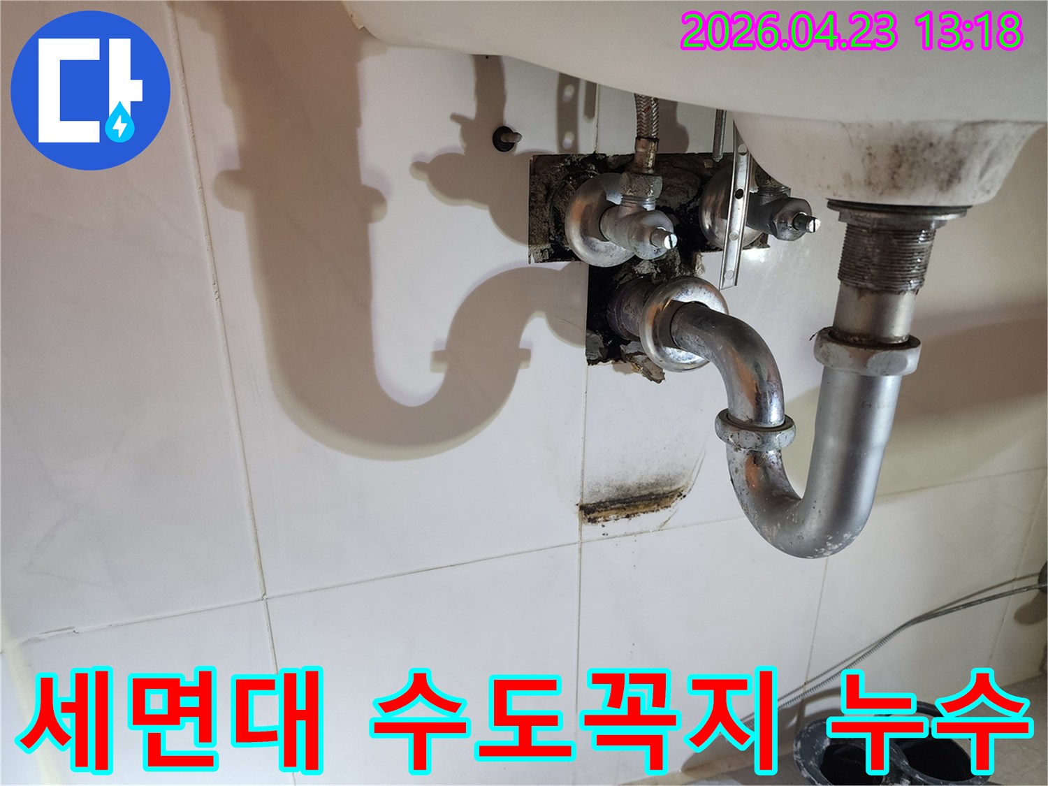 이 이미지는 양주 삼숭동 아파트 화장실 세면대 아래 수도꼭지 배관에서 발생한-누수로 인한 벽면 오염과 곰팡이를 보여줍니다.