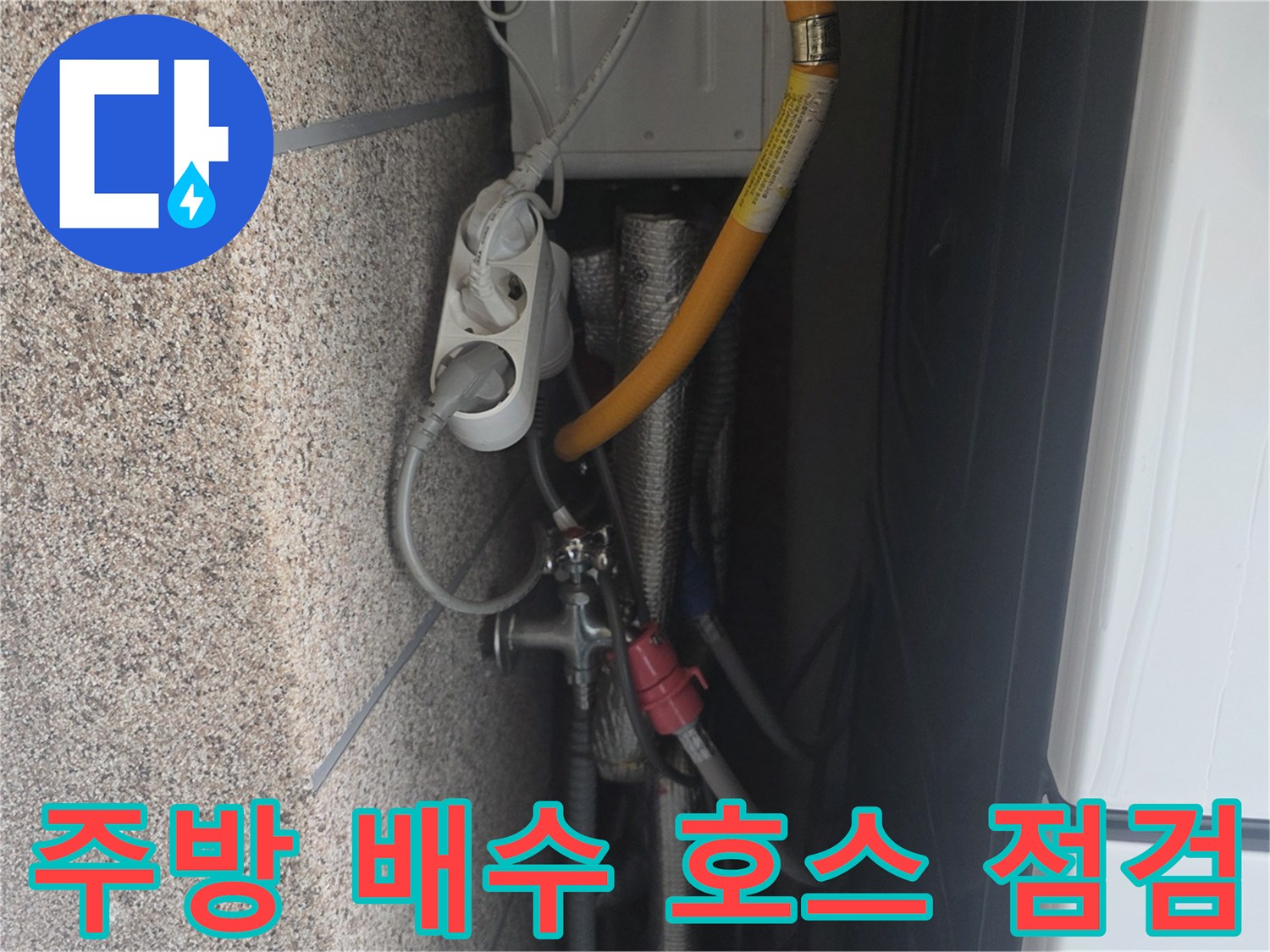 싱크대 하부의 노란색 배관과 은색 부속 주변의 누수 여부를 확인 중입니다