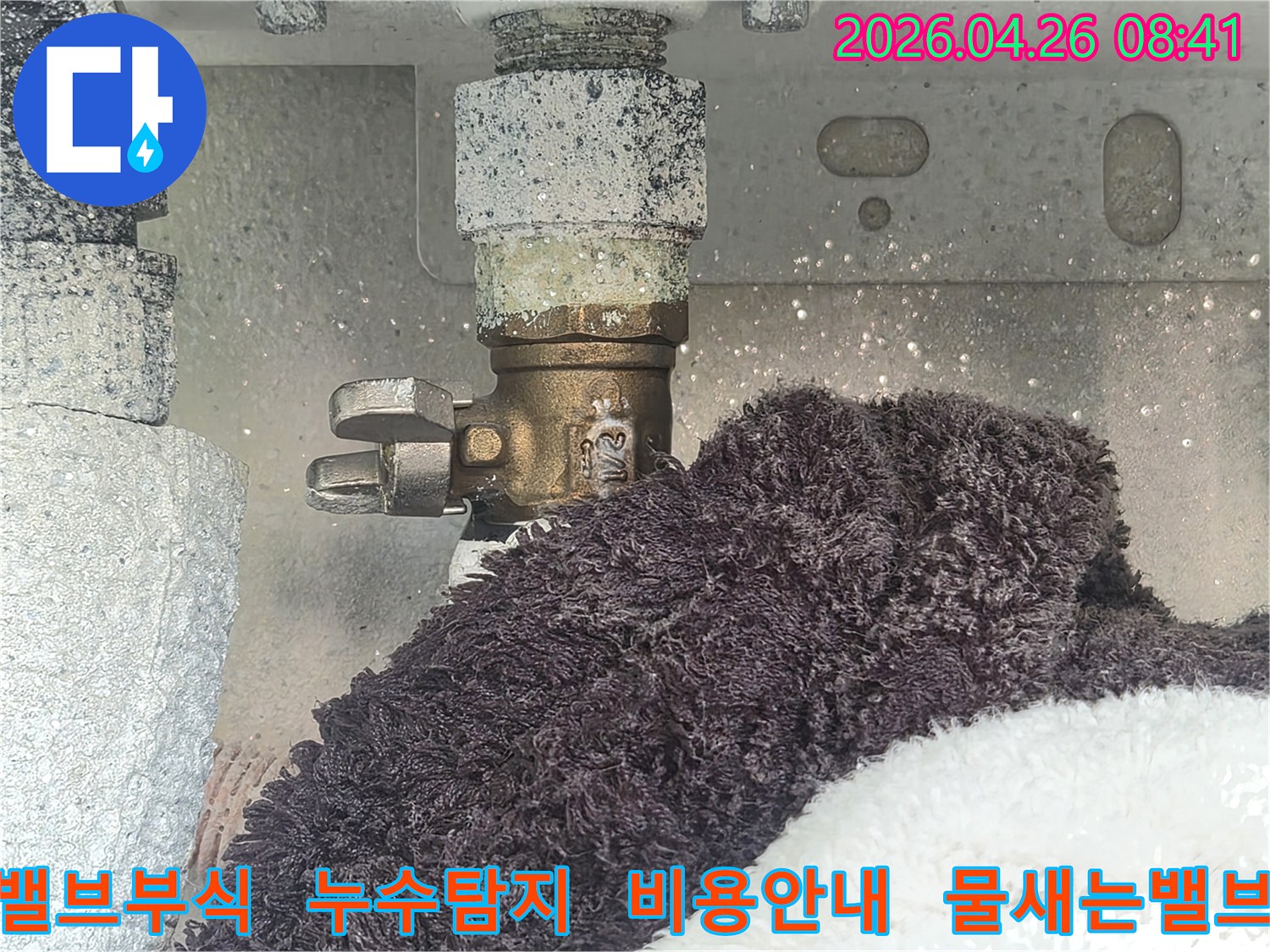 부식으로 인해 하얗게 변색된 수도 밸브에서 물이 새고 있는 현장-아래 수건이 젖어있는 모습-누수 탐지 비용 상담을 위한 초기 진단 사진