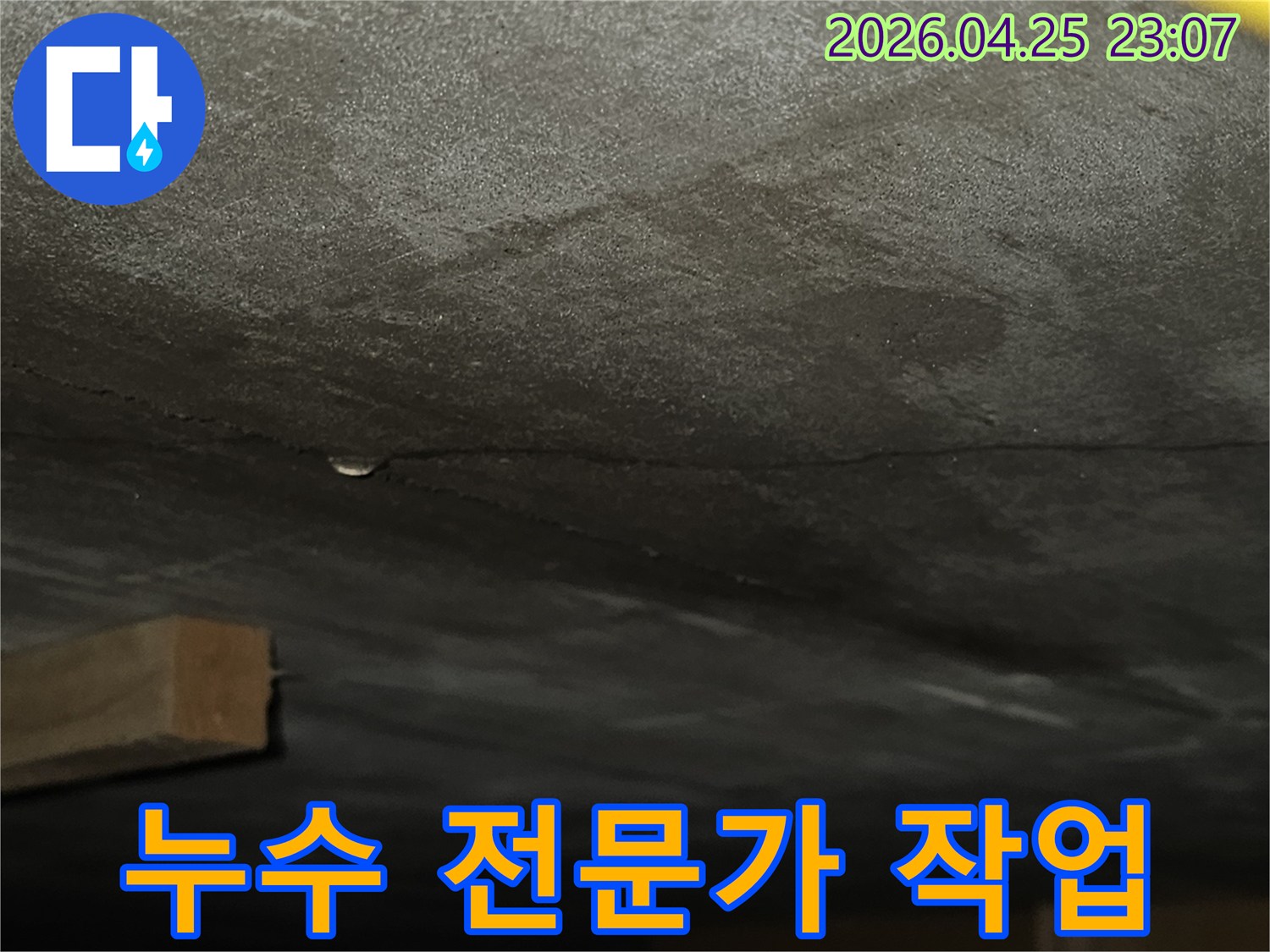 벽면에 생긴 균열을 따라 물기가 스며들어 어둡게 변색된-누수 현장의 상세 모습으로-전문가의 섬세한 탐지 작업이 필요한 상황