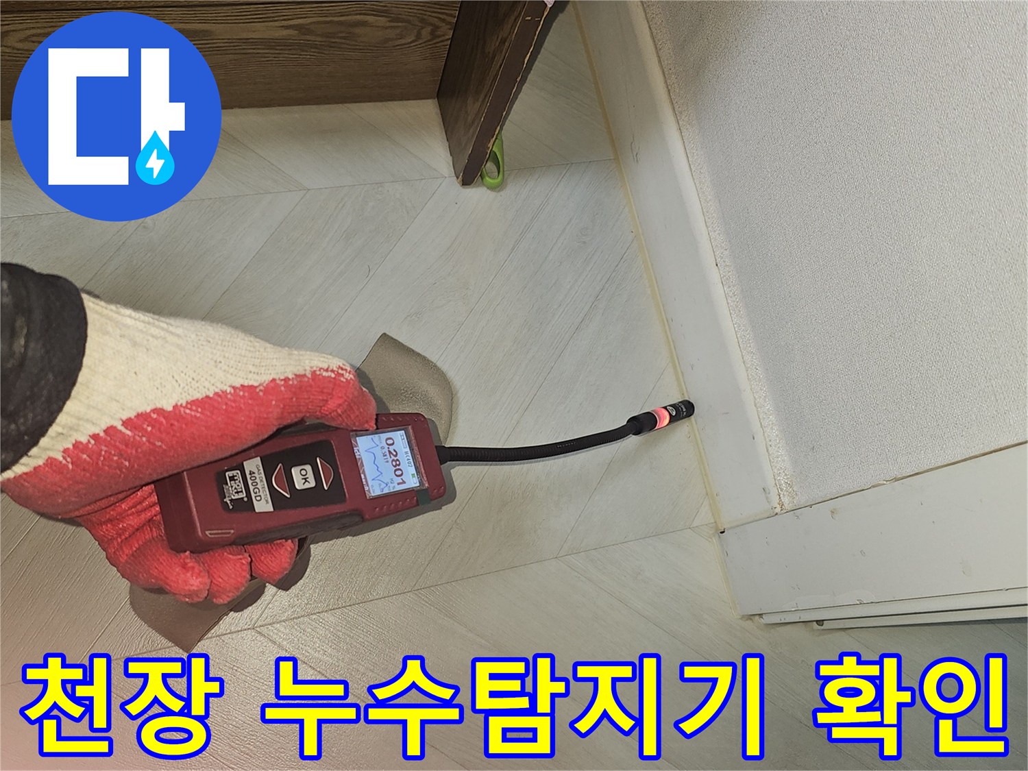 숙련된 전문가가 누수 탐지 장비로 천장 모서리 부근의 미세한 누수 지점을 확인하는 모습