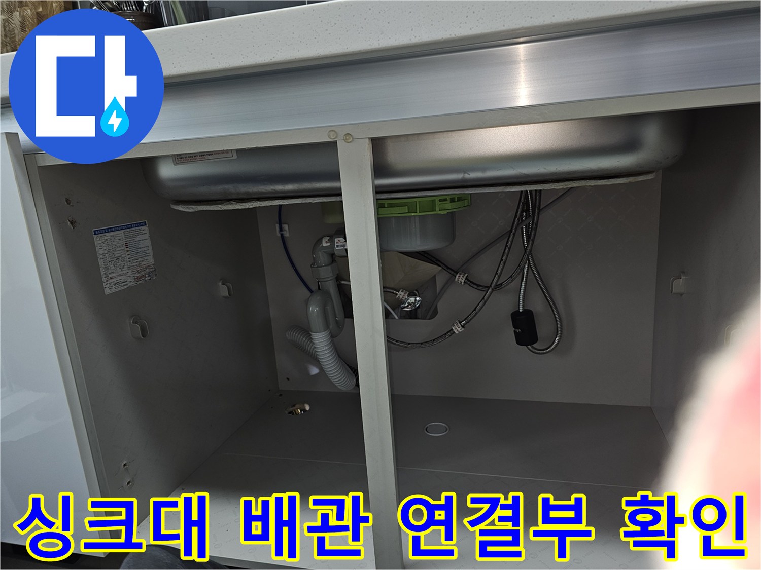 주방 싱크대 하부의 배관 연결 부위를 근접 촬영한 이미지로-누수 발생 가능성이 높은 지점을 집중적으로 점검하고 있습니다.