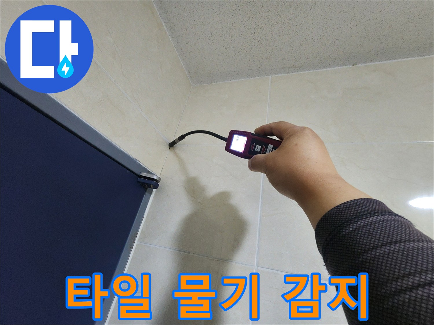 누수 전문 엔지니어가-타일 벽면의 미세한 틈새에서-고성능 탐지기로-숨겨진 물기를 정확히 감지하고 있습니다.