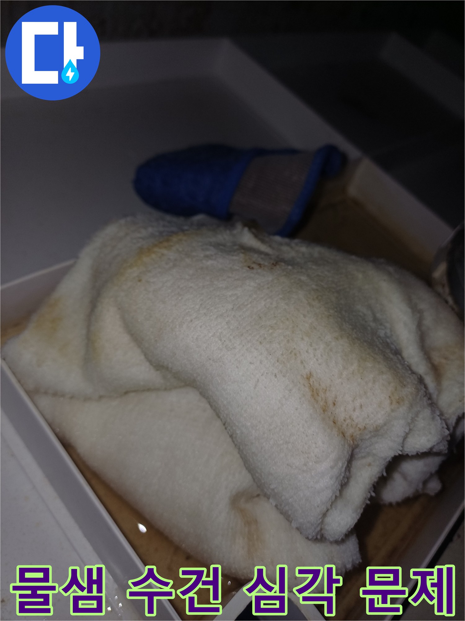 물에 젖어 얼룩이 생긴 수건이 상자 안에 놓여 있는-누수 피해가 진행 중임을 보여주는 현장 사진입니다.
