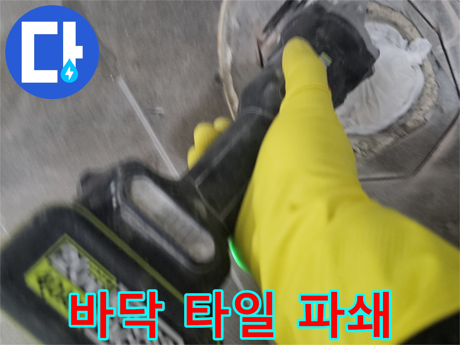 노란색 작업 장갑을 착용한-전문가가-전동 공구로-오수 배관 주변의 바닥 타일을-세심하게 파쇄하는 과정입니다.