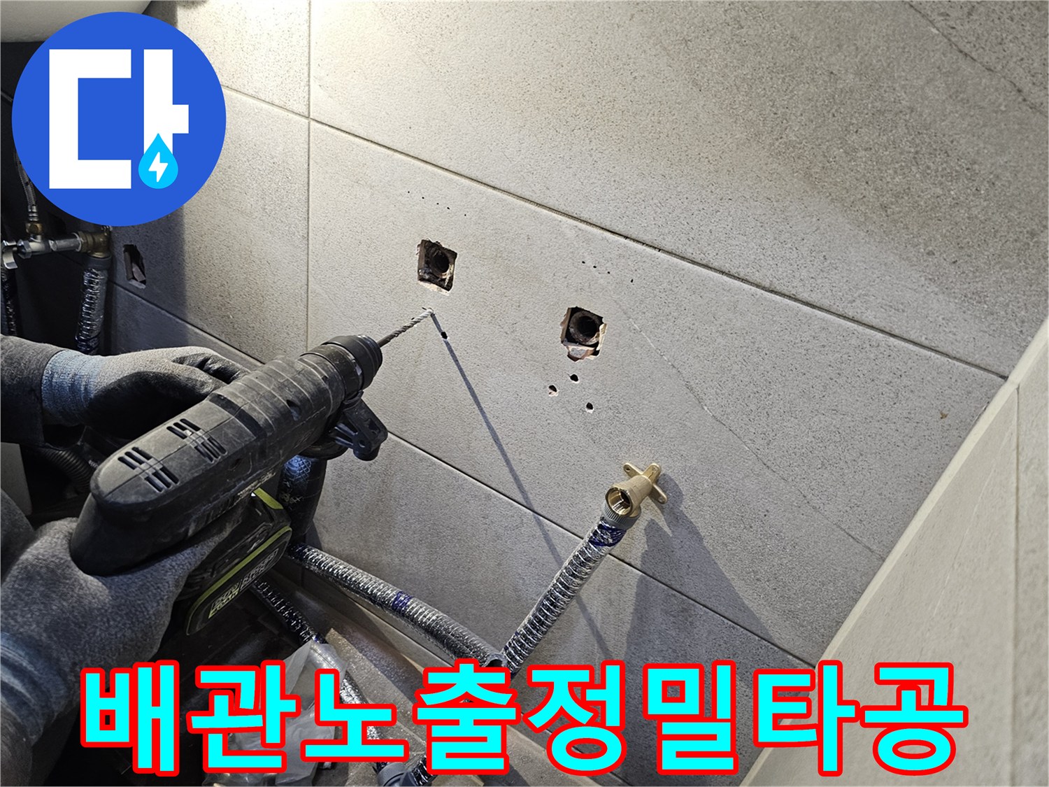 욕실 타일 벽에-배관 노출 부위를 위한-정밀한 타공 작업을 진행하는 모습